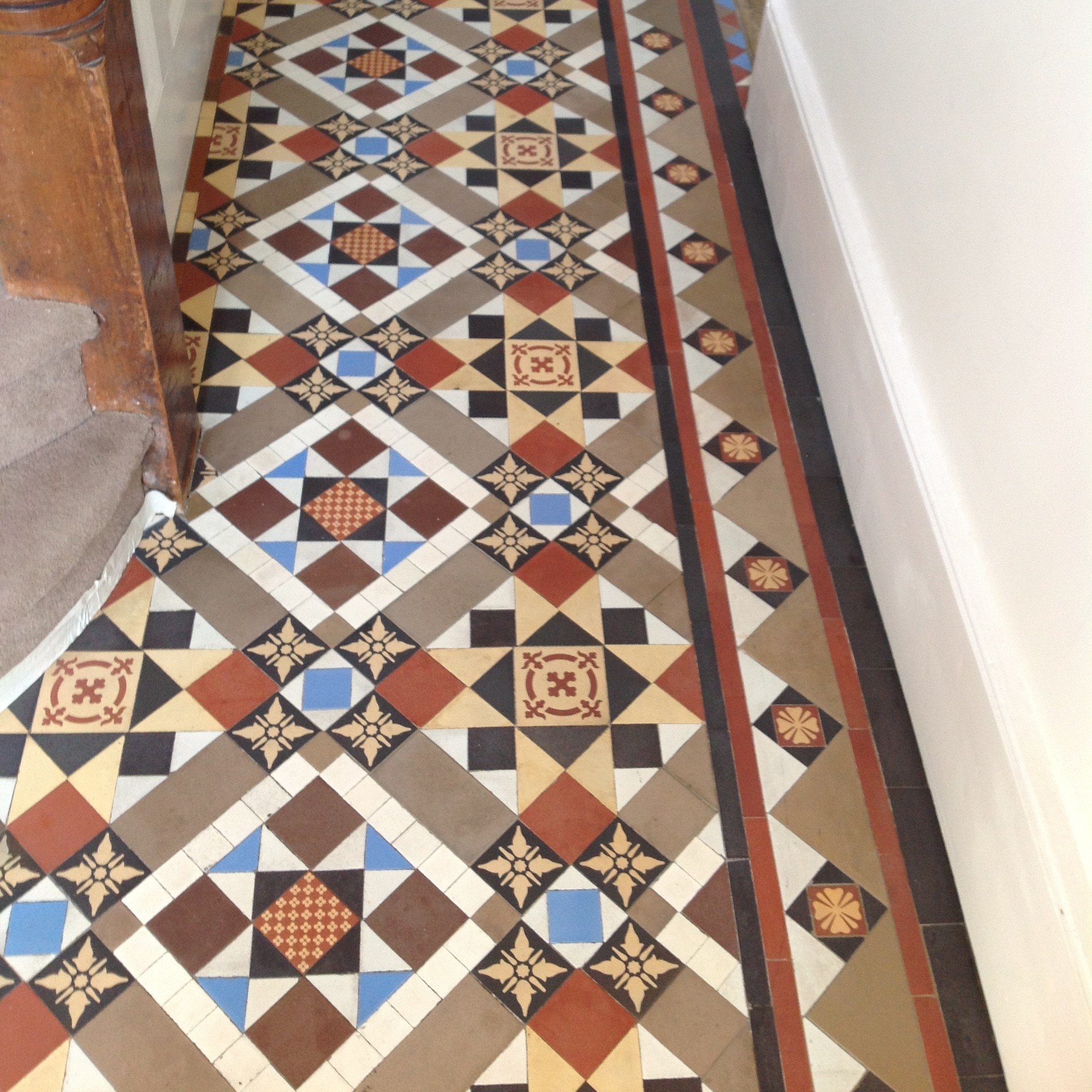 Colorful geometric patterned tile floor with a decorative border along the edges.