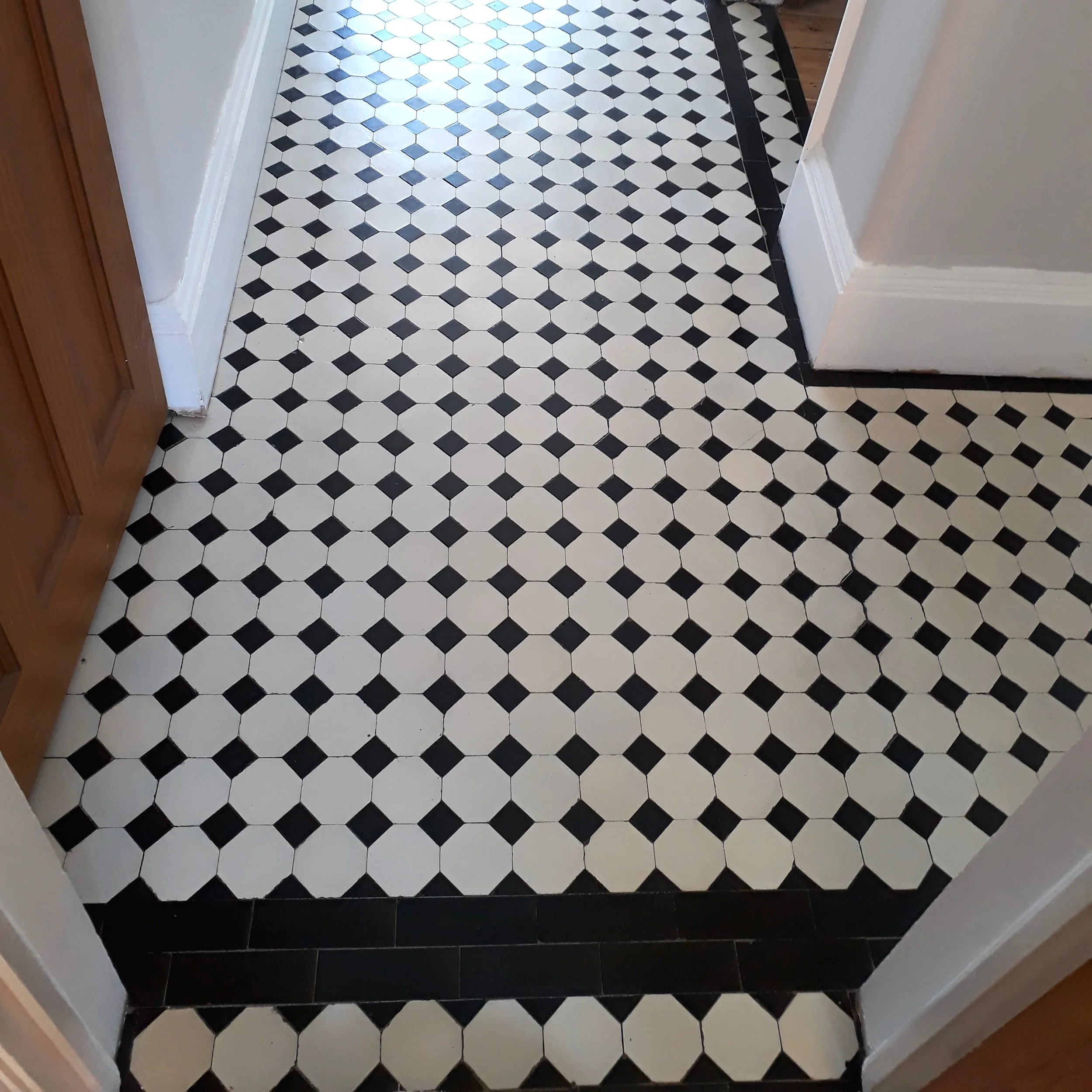 Hallway with tiled pattern formed of a white octagon and a black dot with a black outside edge