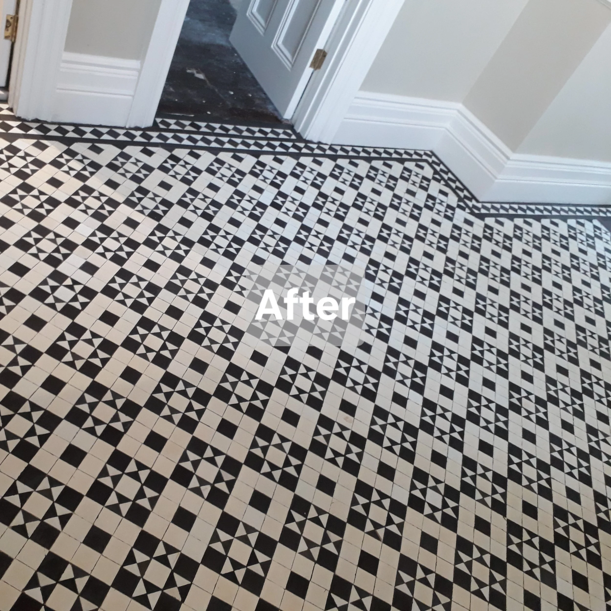 Refinished black and white geometric patterned tile floor in a room next to a doorway.
