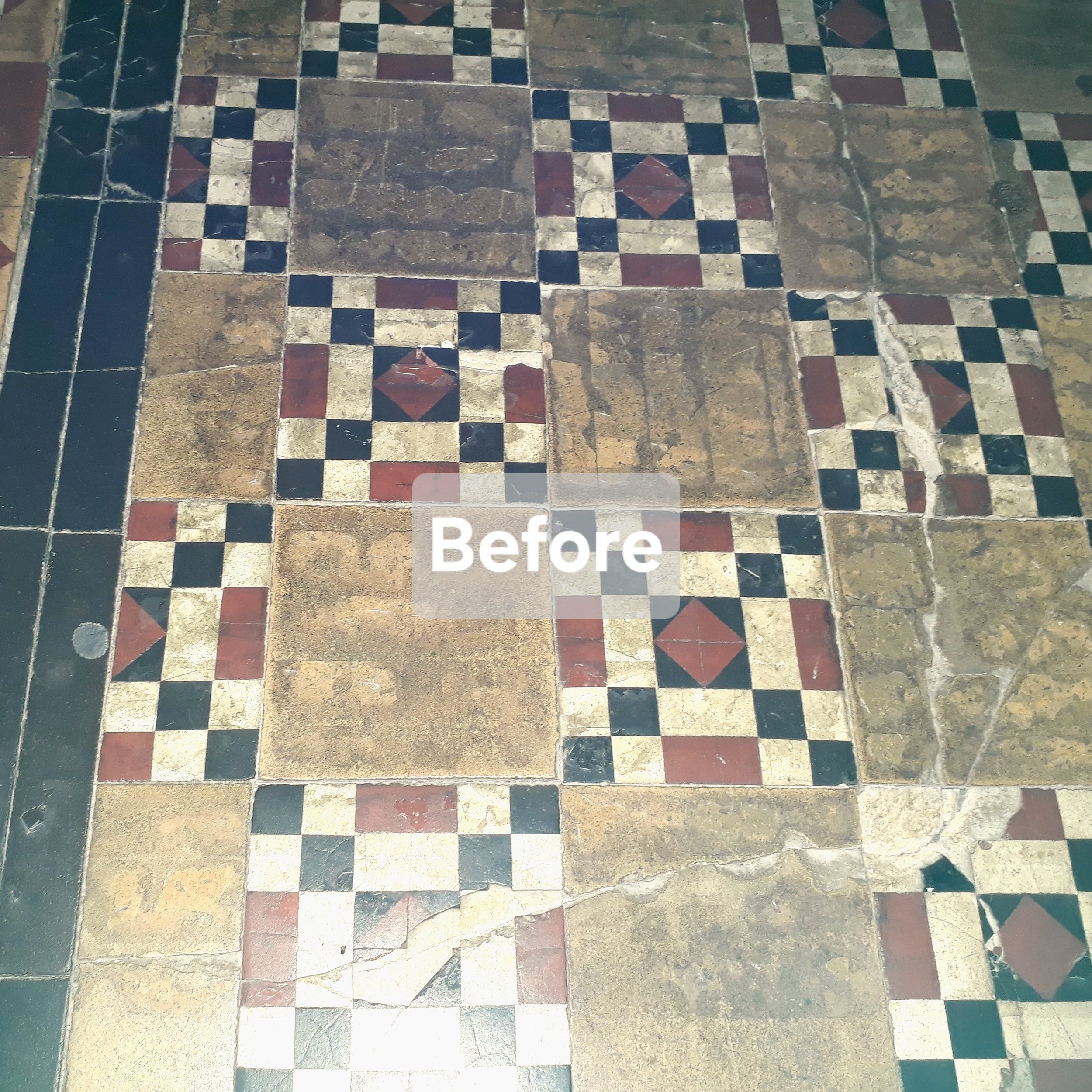 Old, damaged, tile floor with a checkered pattern of black, red, cream, and brown tiles, some tiles are cracked or missing.