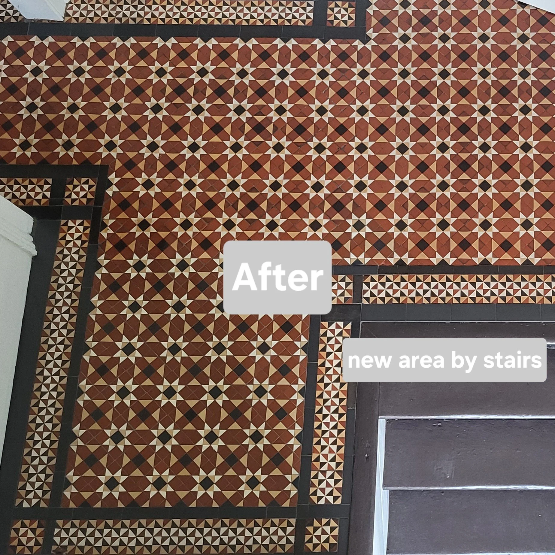 Decorative black and white geometric patterned tile floor with stairs and a new area by stairs