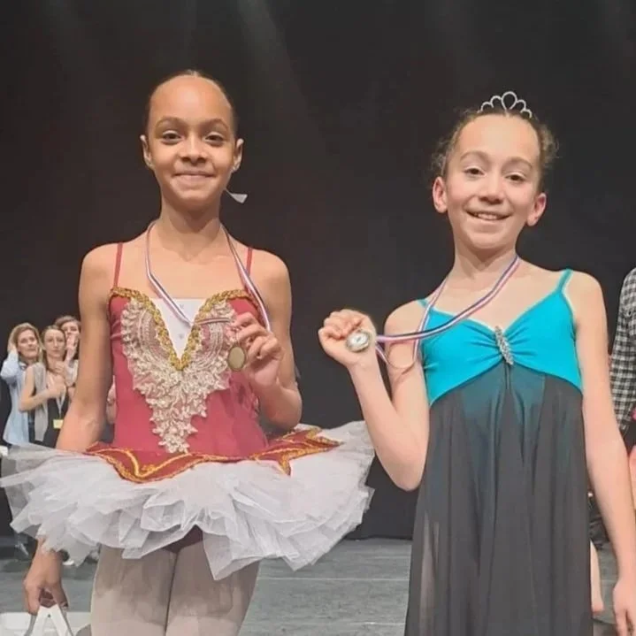Deux jeunes filles en costumes de ballet, tenant des médailles. résultat concours de danse.