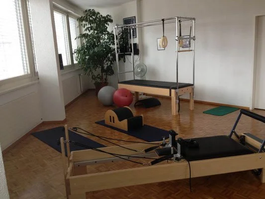 Salle de Pilates, avec équipements d'exercice, tapis, ballon de gymnastique, barre de traction, machine à ressorts.