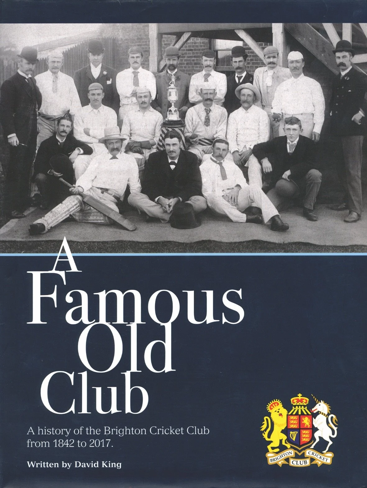 Cover of a book titled 'A Famous Old Club: A history of the Brighton Cricket Club from 1842 to 2017', written by David King, featuring a black-and-white photograph of a group of men in vintage cricket attire and formal clothing, with some holding cricket equipment, in front of a brick building.