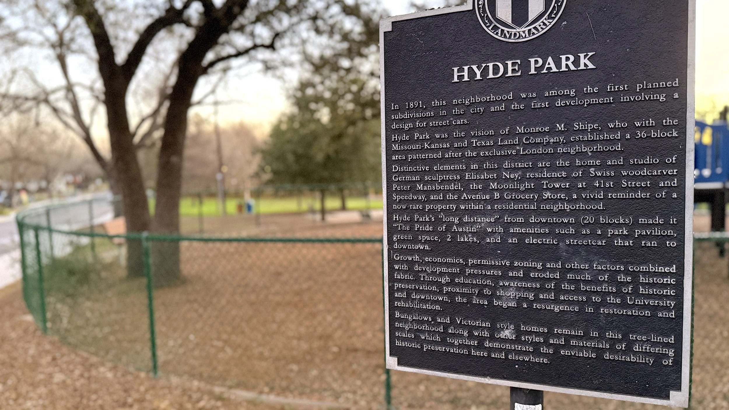 A photograph showing the west side of Shipe Park's playground with the Park's historical marker in the foreground.