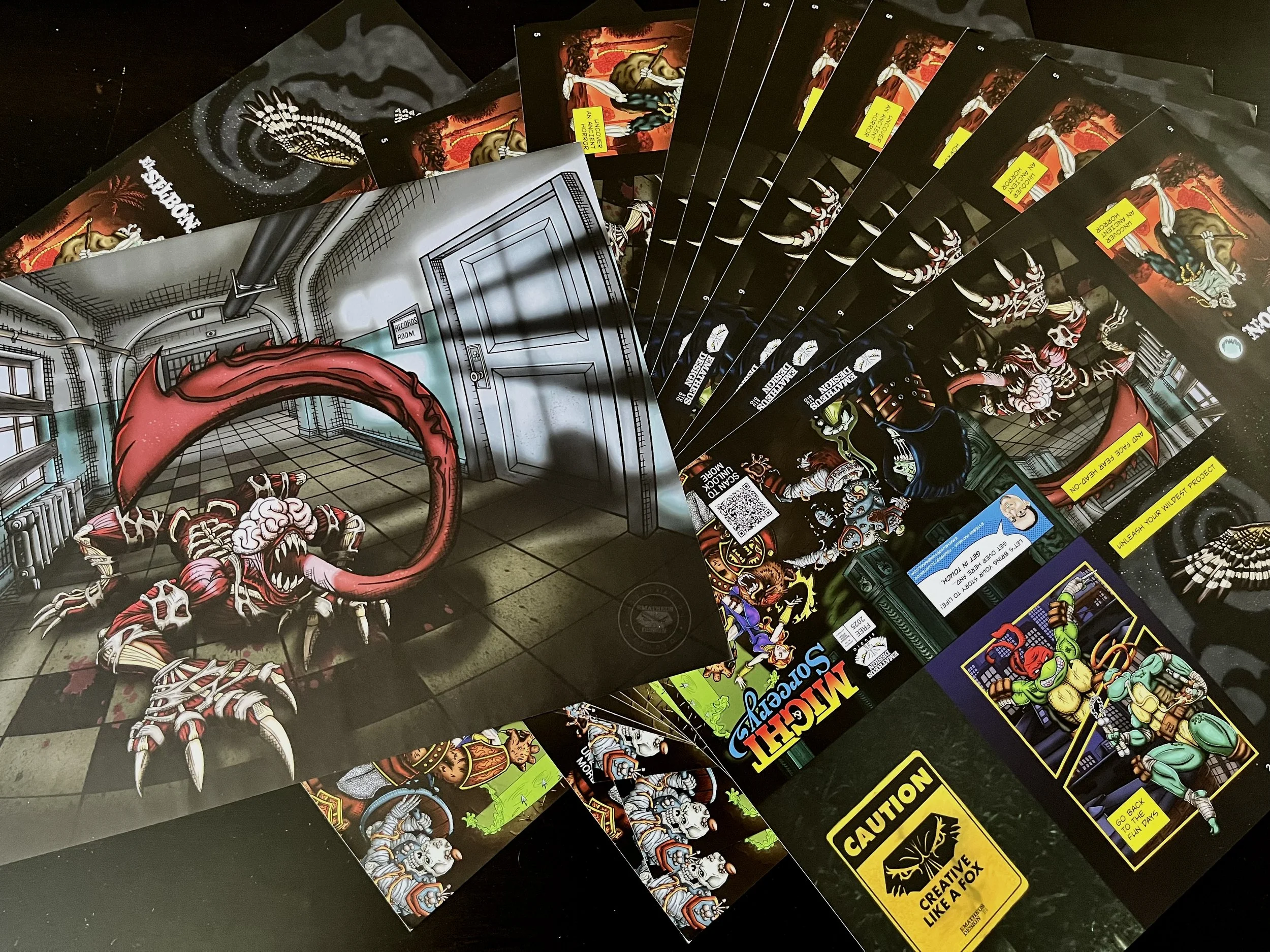 A group of posters and zines with custom comic illustrations spread  on a table