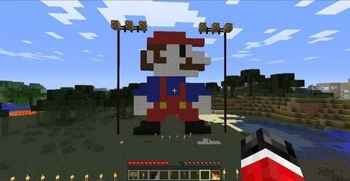 A Minecraft game screenshot showing a giant Super Mario built with blocks.