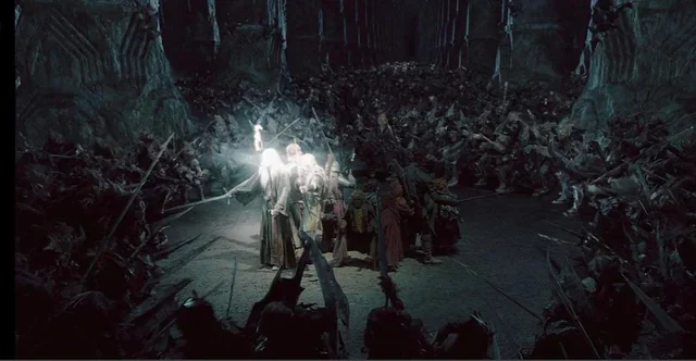Screenshot from the movie LoTR Fellowship of the Ring. It shows Gandalf, Aragorn, Legolas, Gimly and the hobbits back-to-back, facing a horde of orcs deep in the mines of Moria