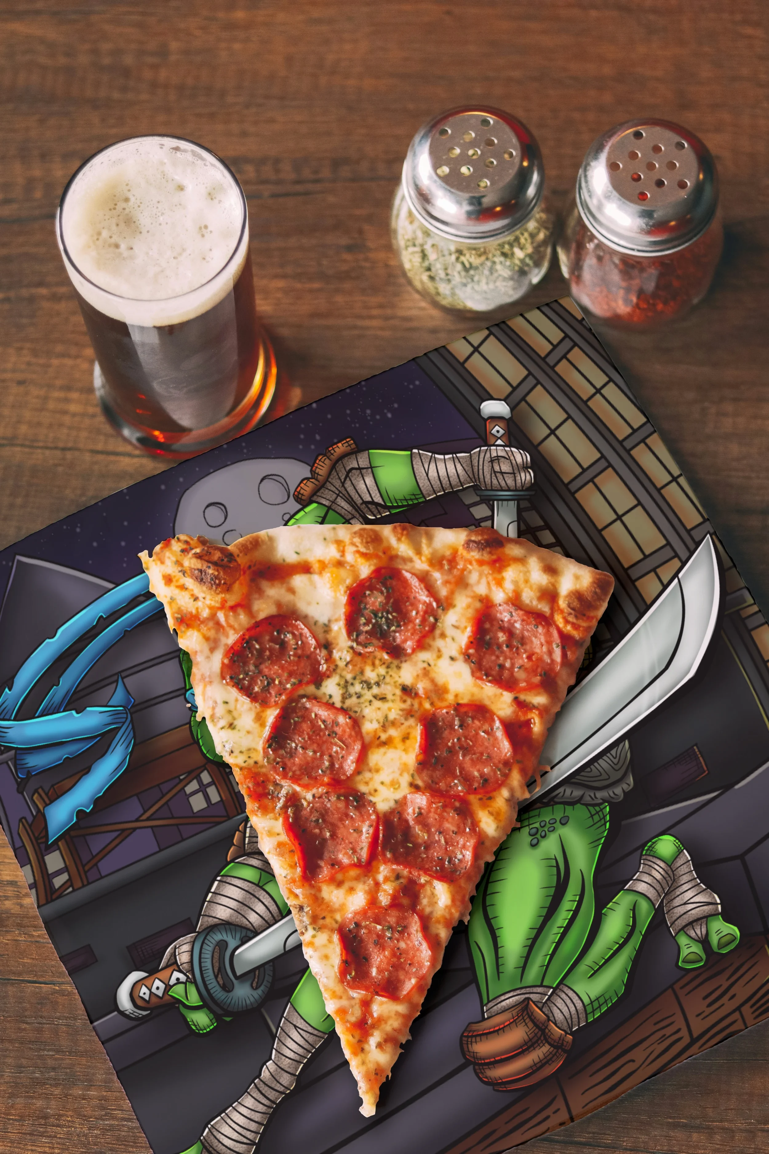 Top view of a slice of pepperoni pizza over a napkin decorated with a hand-drawn comic-style illustration of Leo from the TMNT