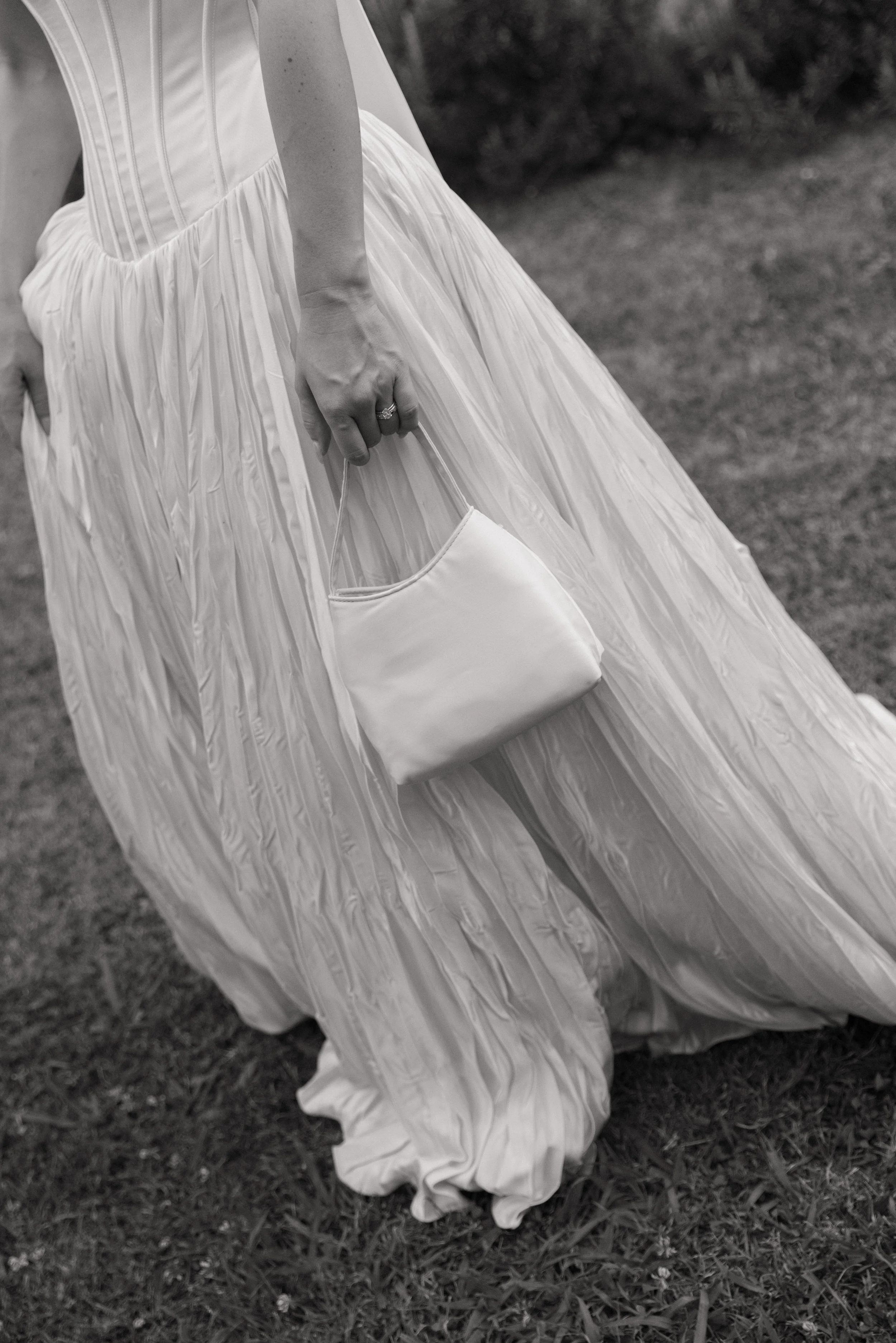 a girl in a white gown holding a purse black and white image