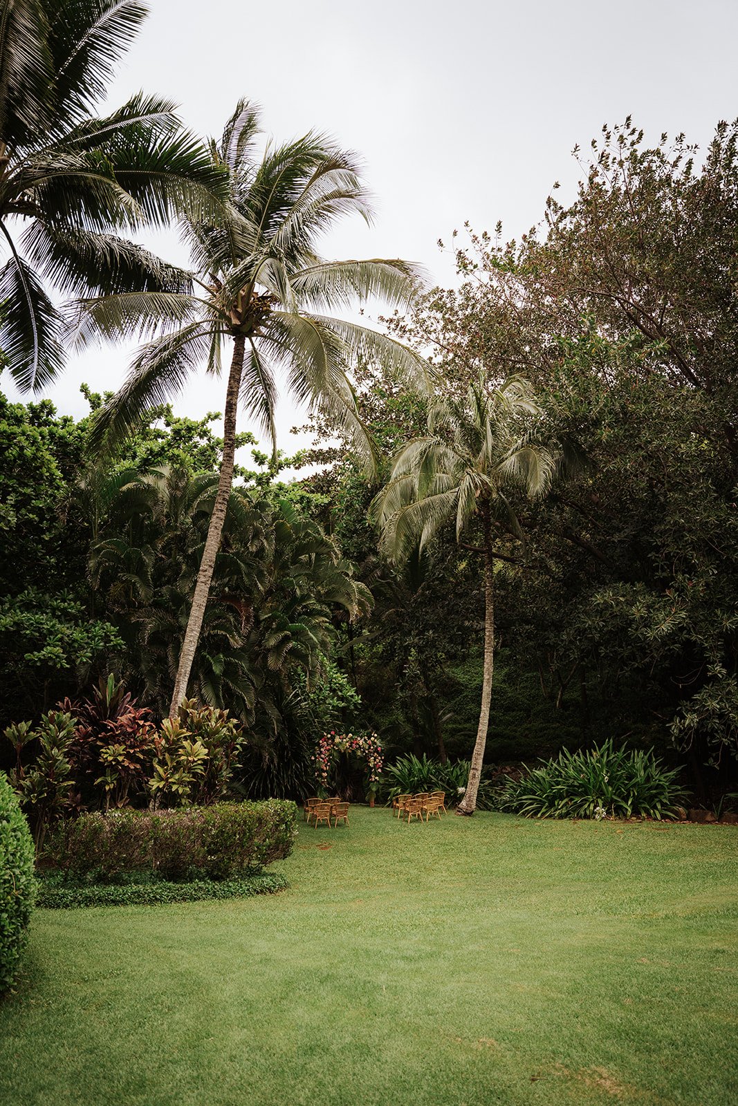 A floral ceremony arch in palm trees in garden