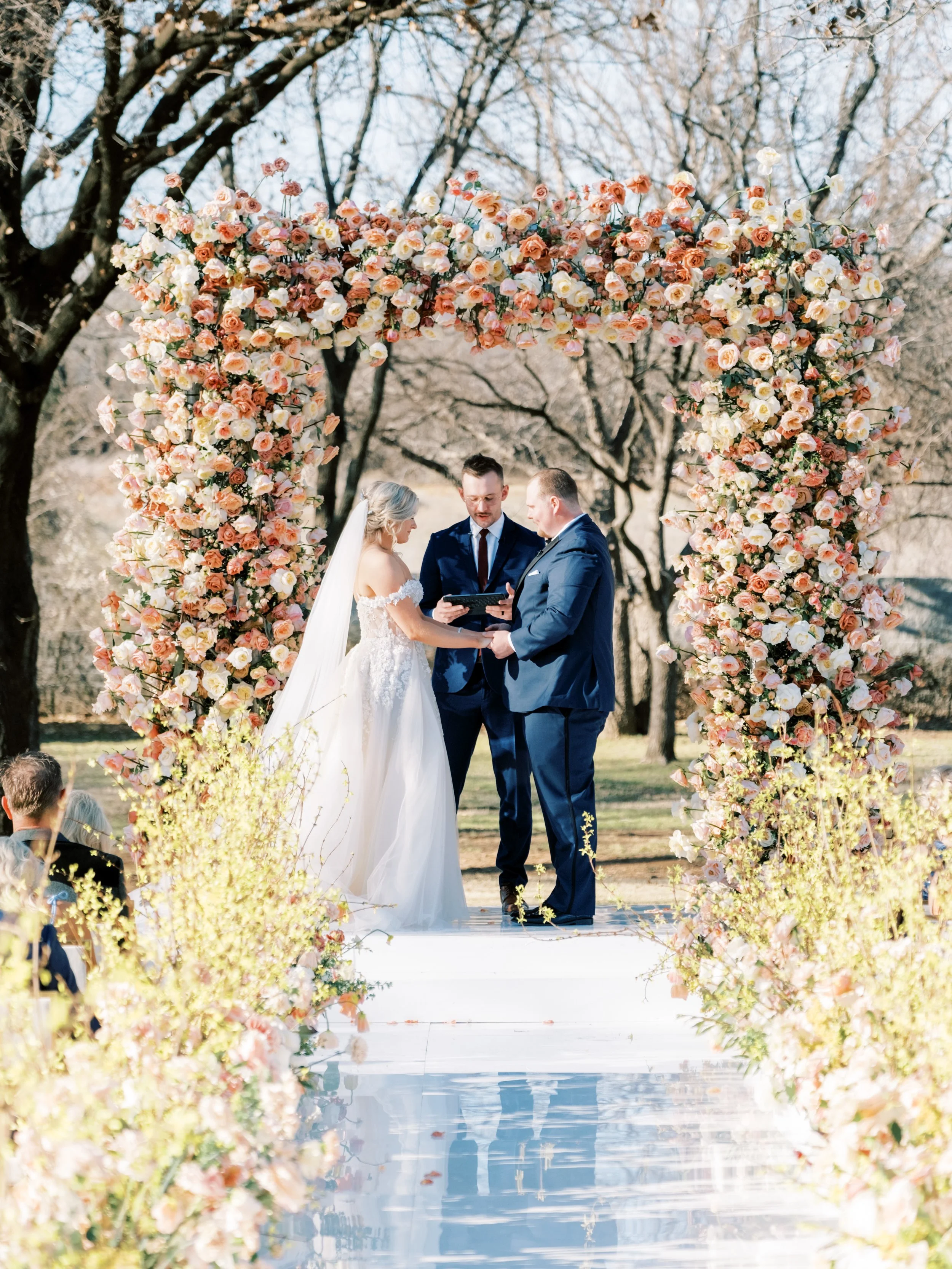 large floral arch wedding with peach roses and floral aisle with forsythia at the Olana