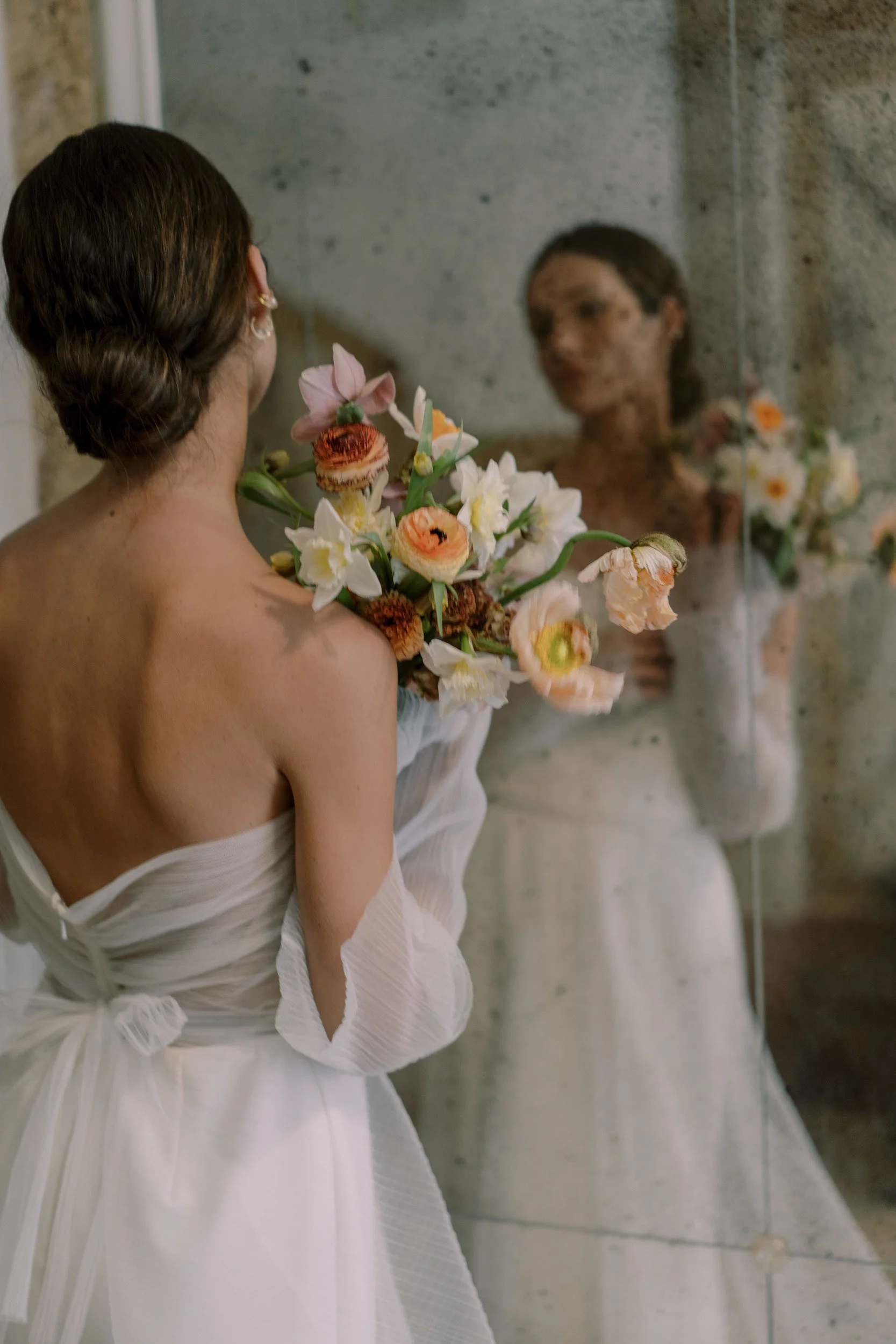 luxury bride in couture gown holding a bouquet looking in mirror Venice