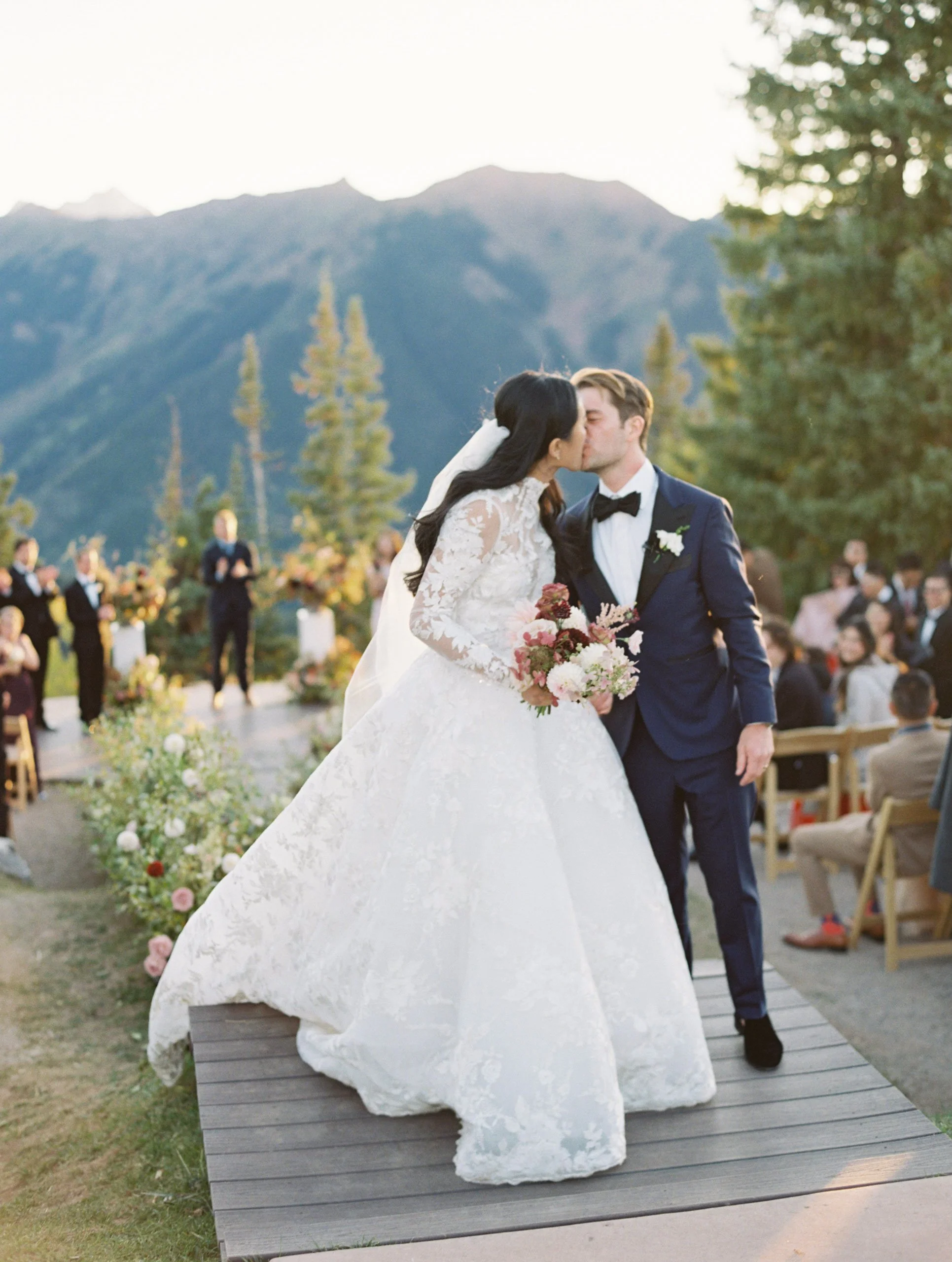 bride an groom kissing each other with people clapping in background