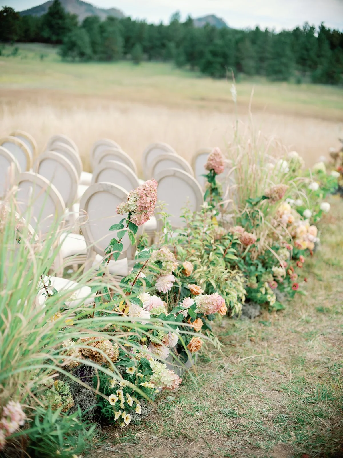 chairs in a field with florals such as peegee hydrangeas by chairs
