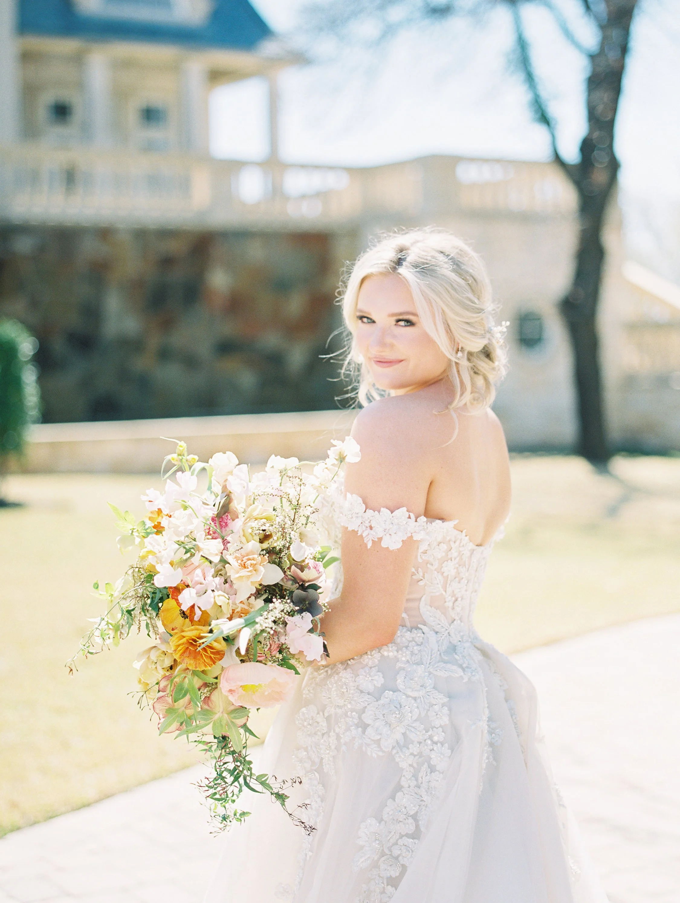 bride holding bouquet looking at the camera in a white dress