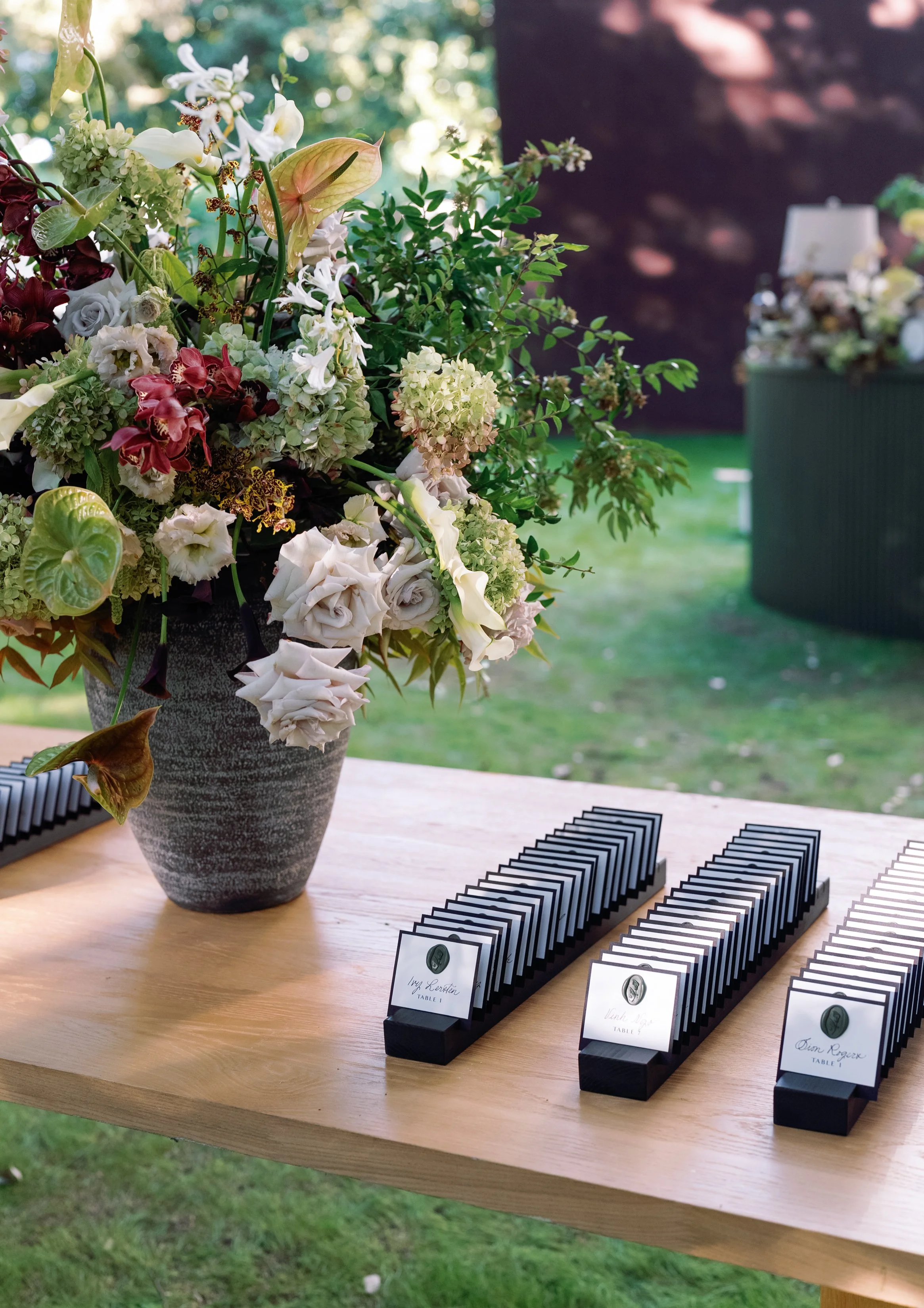 tall lush arrangement with Anthurium and orchids in black vase Nasher wedding reception