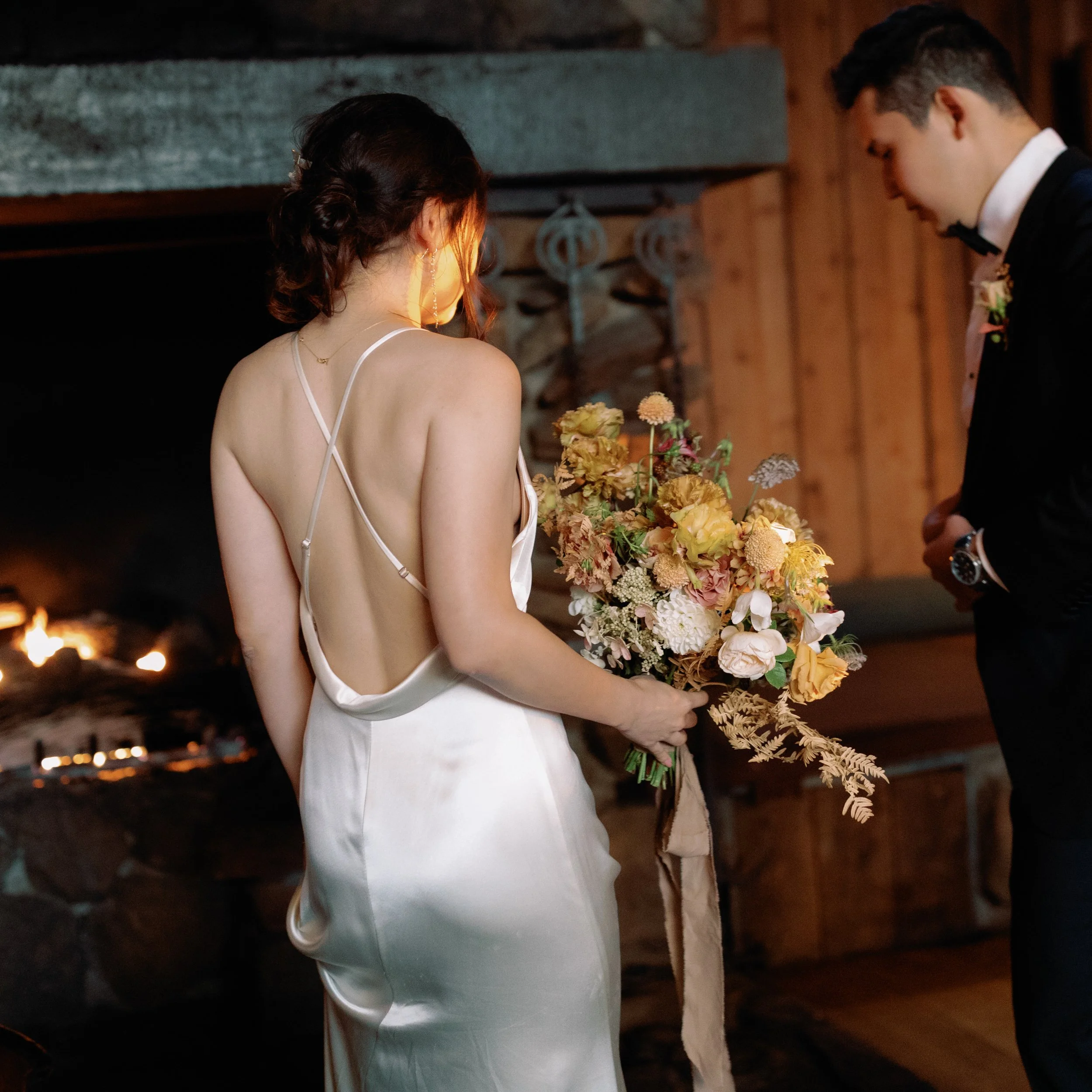 bride holding bouquet by fireplace Timber Cove