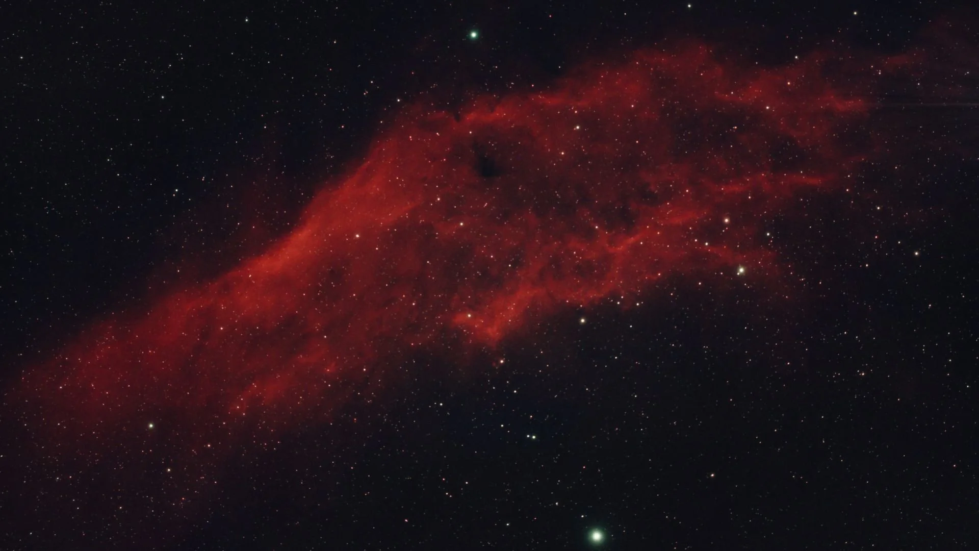 Une image de l'espace avec une nébuleuse rougeâtre et de nombreux étoiles