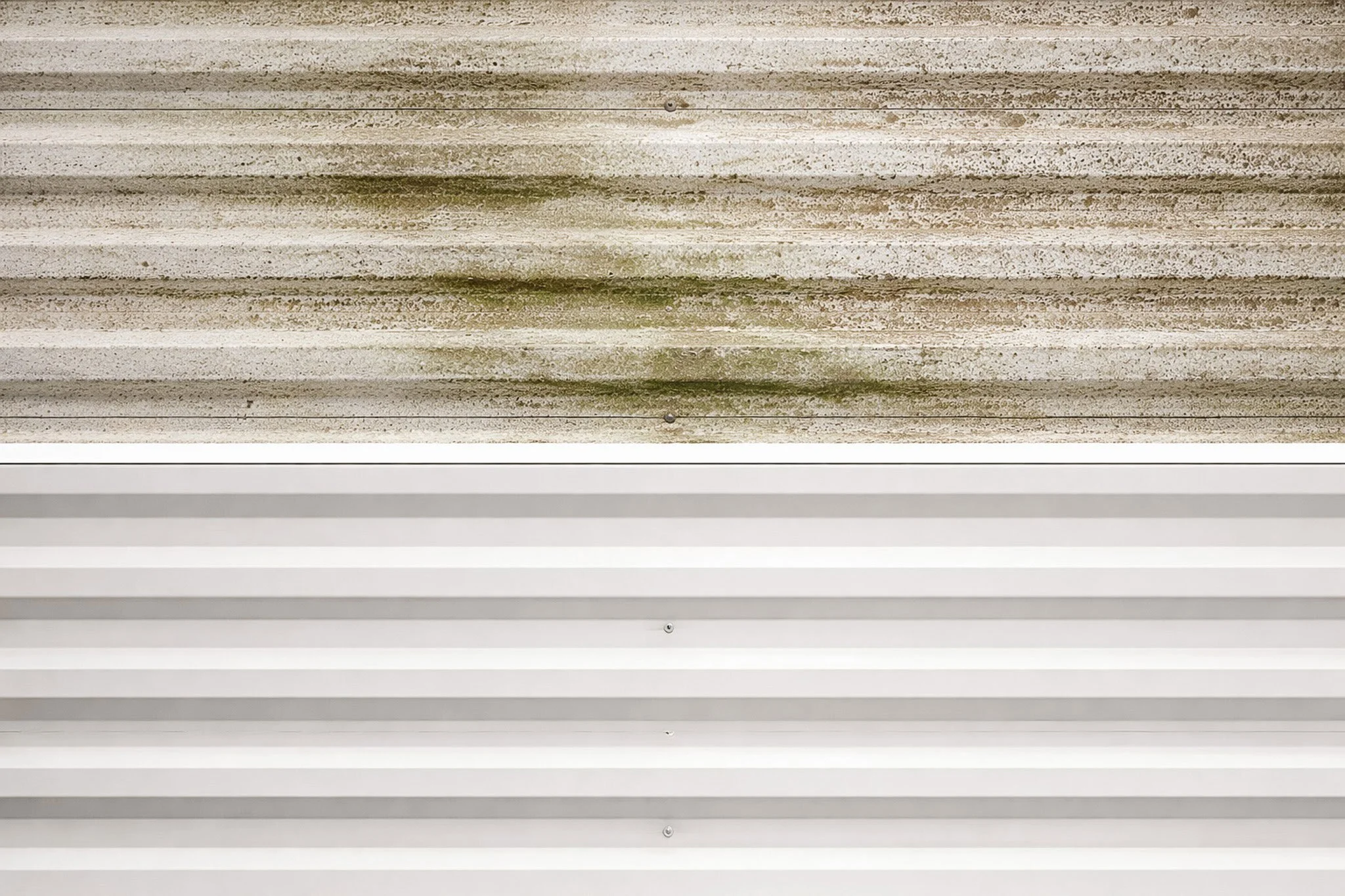 Une photo divisée en deux parties, la partie supérieure montre un plafond en bois dégradé avec de la moisissure, et la partie inférieure montre un plafond en métal blanc propre avec des bandes parallèles.