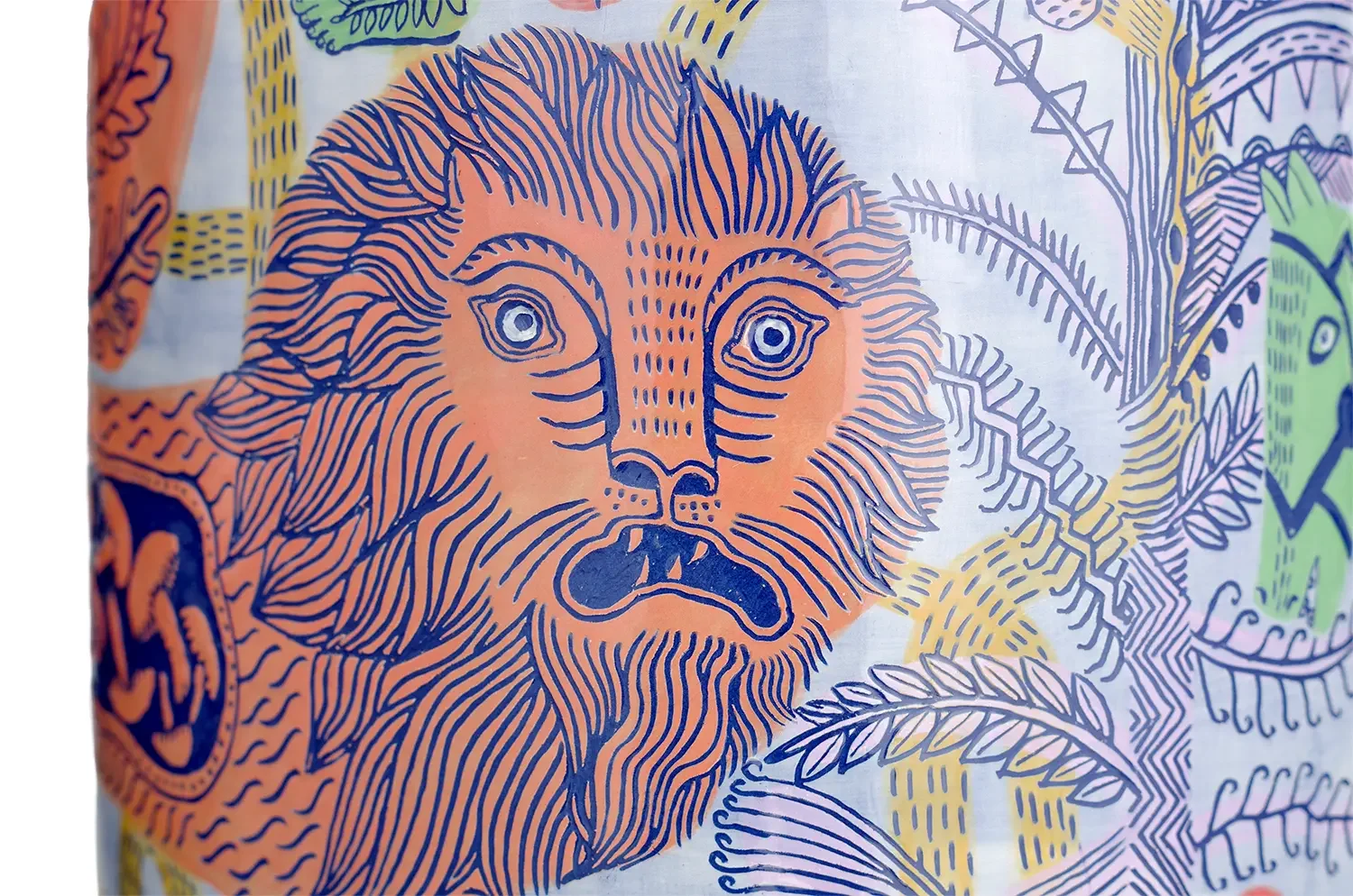 Colourful textile with a line drawing of a lion's face surrounded by abstract patterns and foliage in orange, yellow, green, and blue colours.