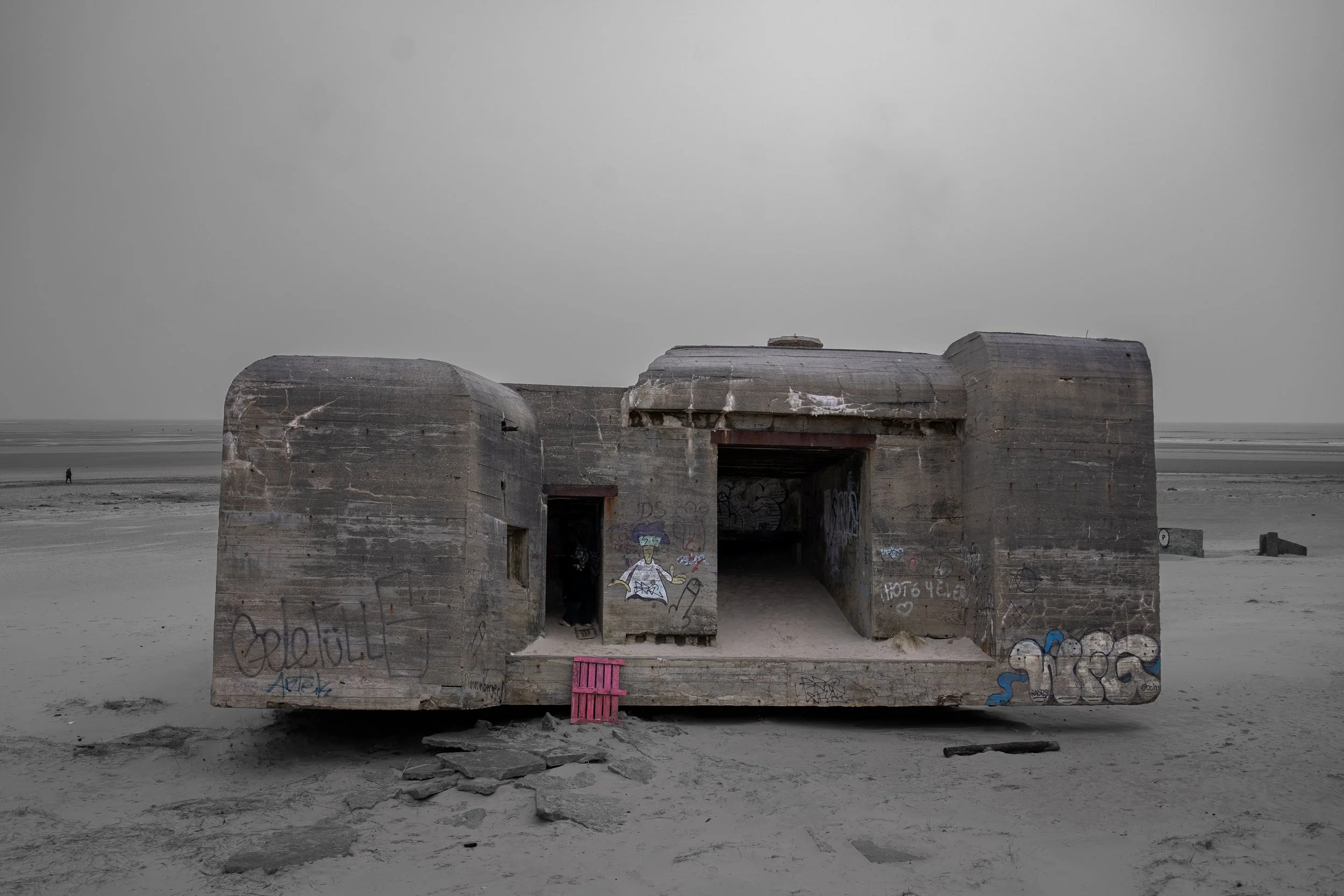 Abandoned concrete bunker on a deserted beach, capturing raw coastal history, decay, and the stark atmosphere of a windswept shoreline.