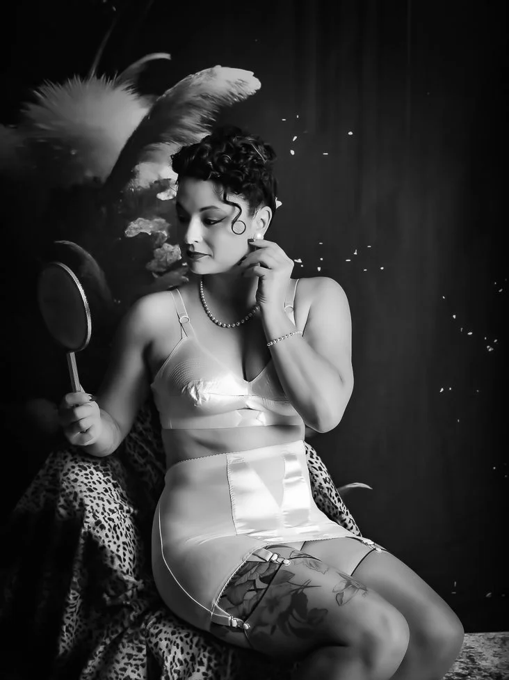 Portrait Boudoir :  lingerie rétro satinée, collier de perles, ambiance feutrée et intimiste.