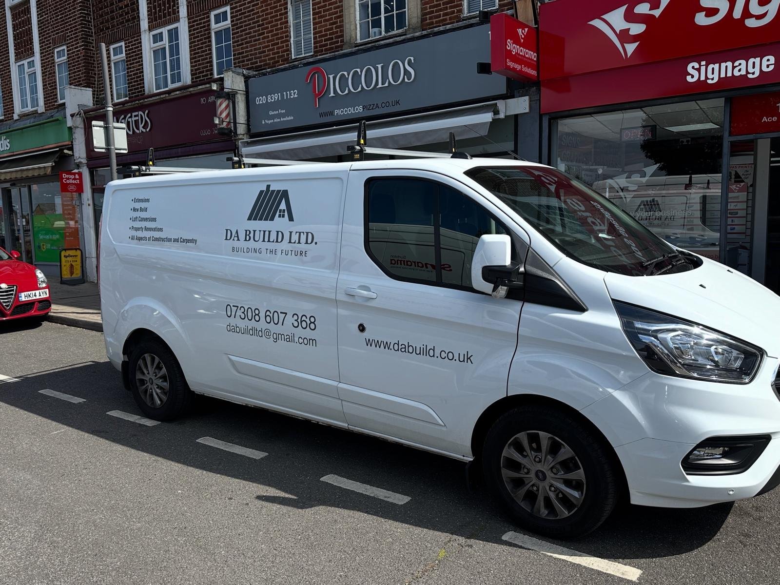 White cargo van parked on the side of the street with business branding, including contact information and logo for DA Build Ltd.