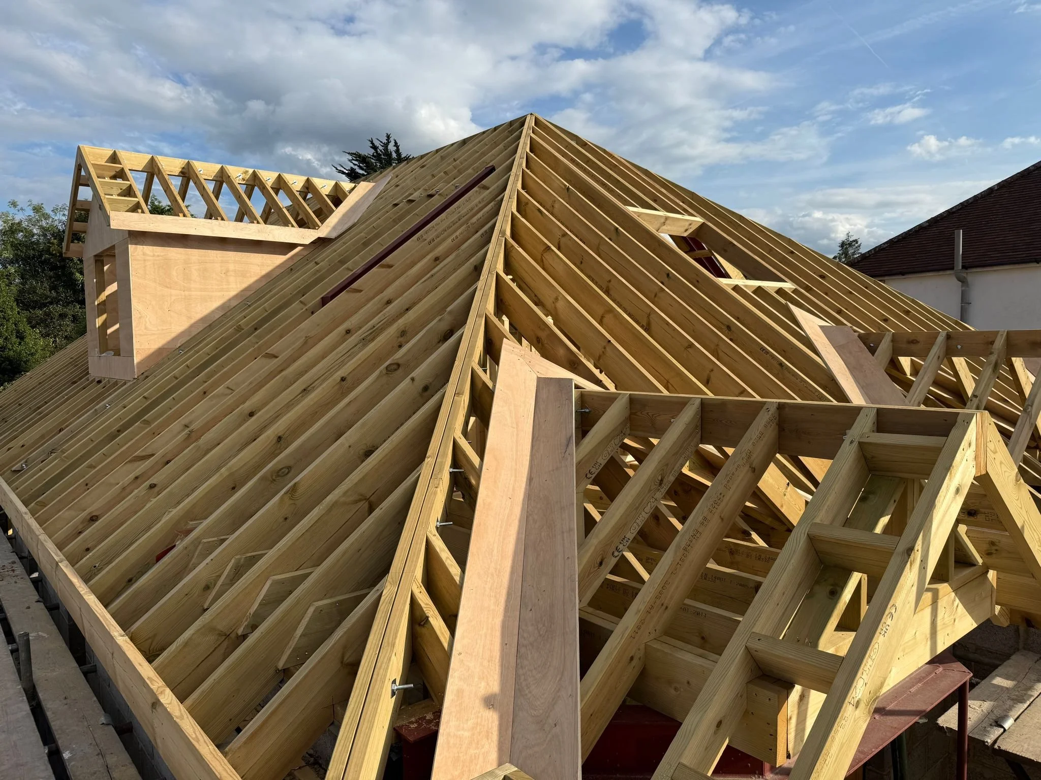 Wooden roof framing under construction, with rafters and support beams. Loft conversion, carpentry, construction and Renovation by DA Build in London, Surrey and Greater London.
