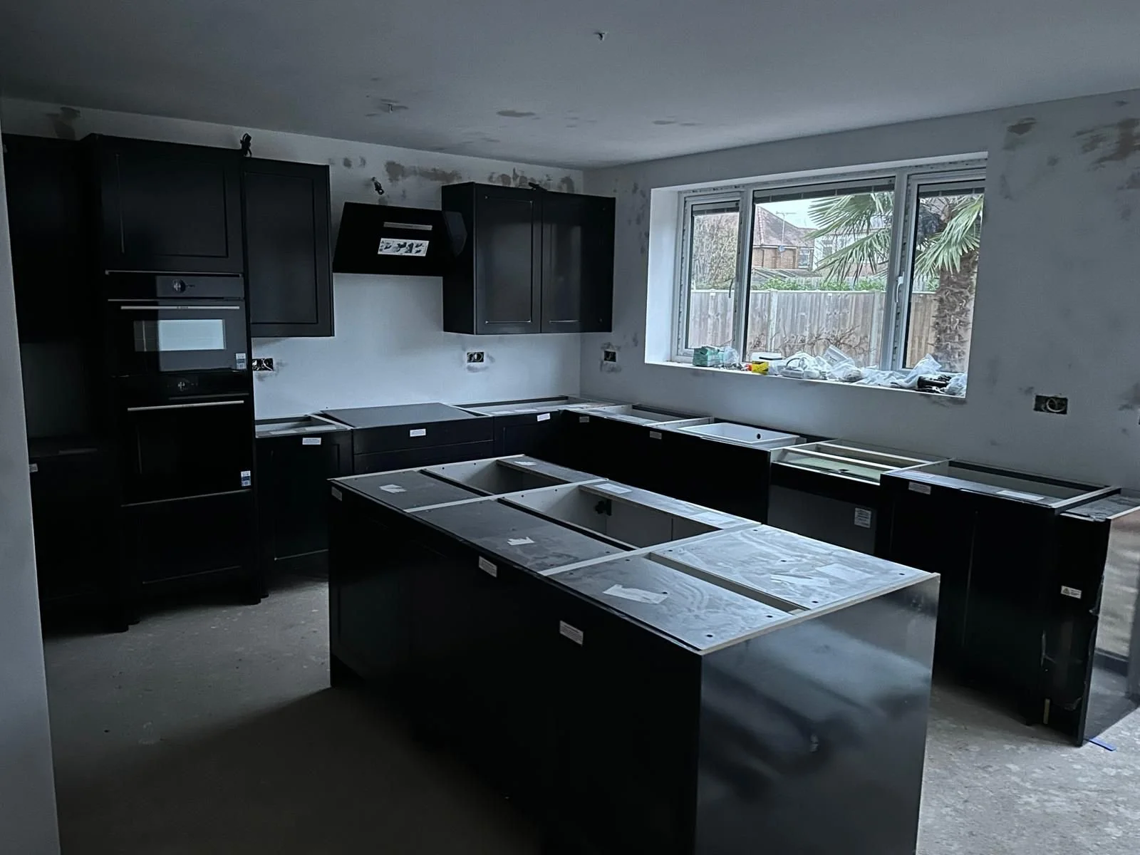 Kitchen under construction with black cabinets.  Carpentry, construction and Renovation by DA Build in London, Surrey and Greater London.