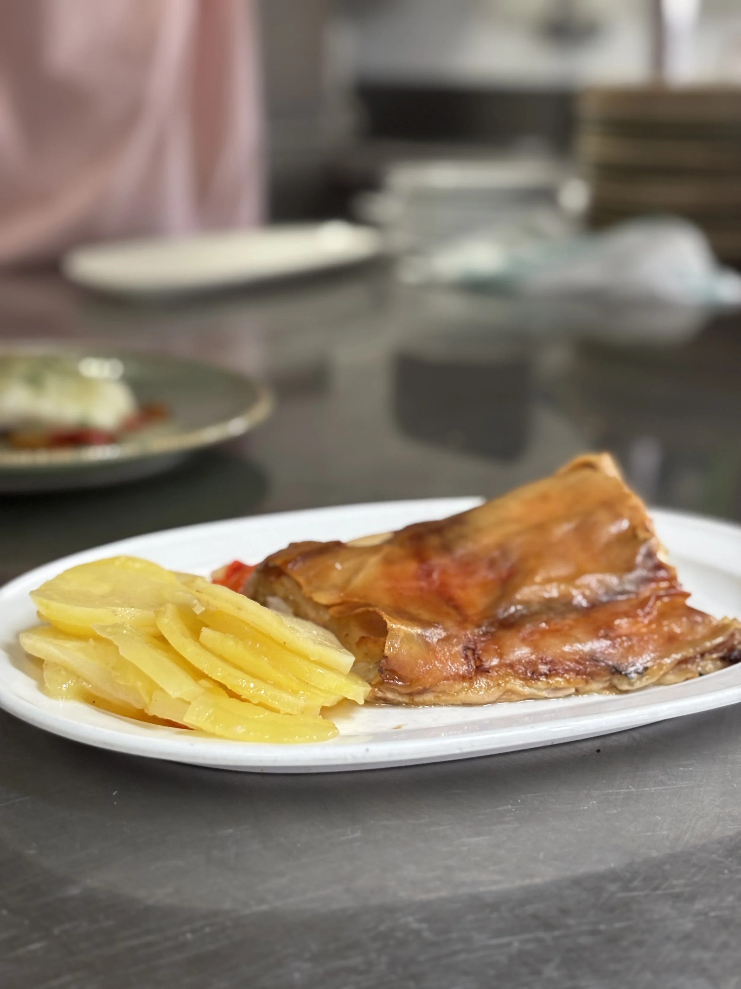 Plato con papas y costillas de cerdo con salsa, en un restaurante o cocina.