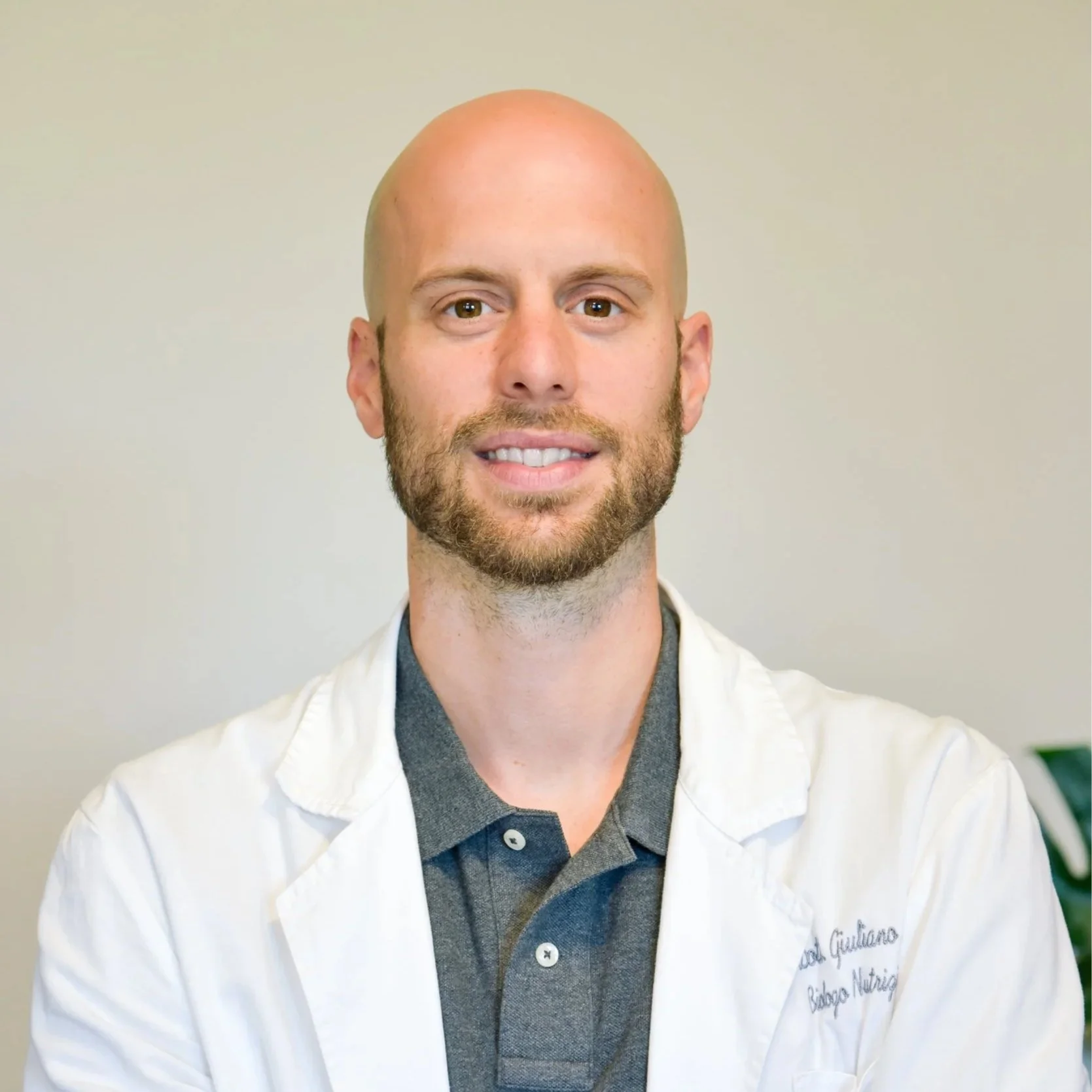 Ritratto professionale in camice del Dott. Giuliano Lodi, biologo nutrizionista esperto in piani alimentari personalizzati.