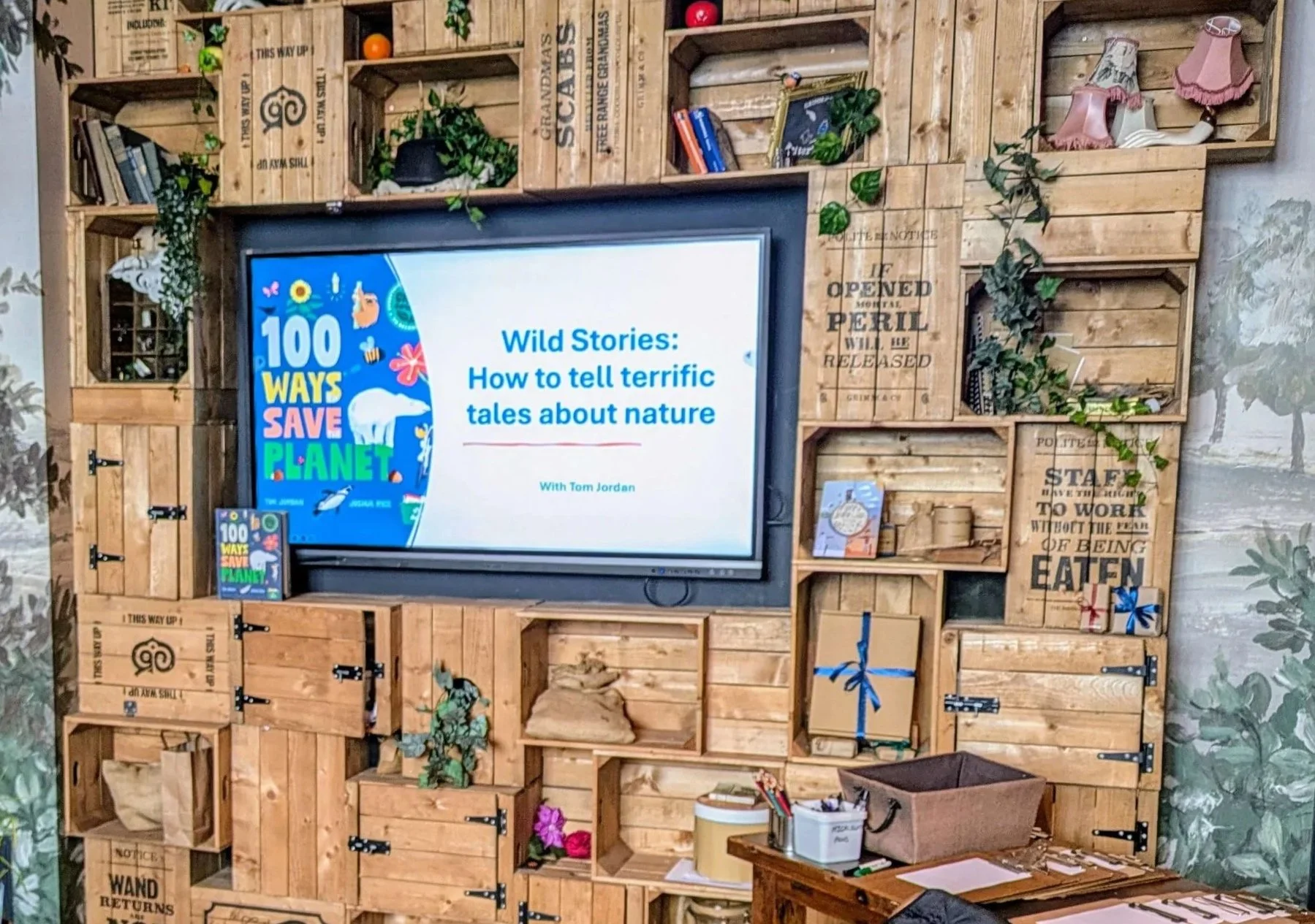 A large display screen from the Grimm & Co Festival of Stories event 'Wild Stories: How to tell terrific tales about nature', based on the book titled '100 Ways Save Planet' by TomJordan and Joshua Rice.