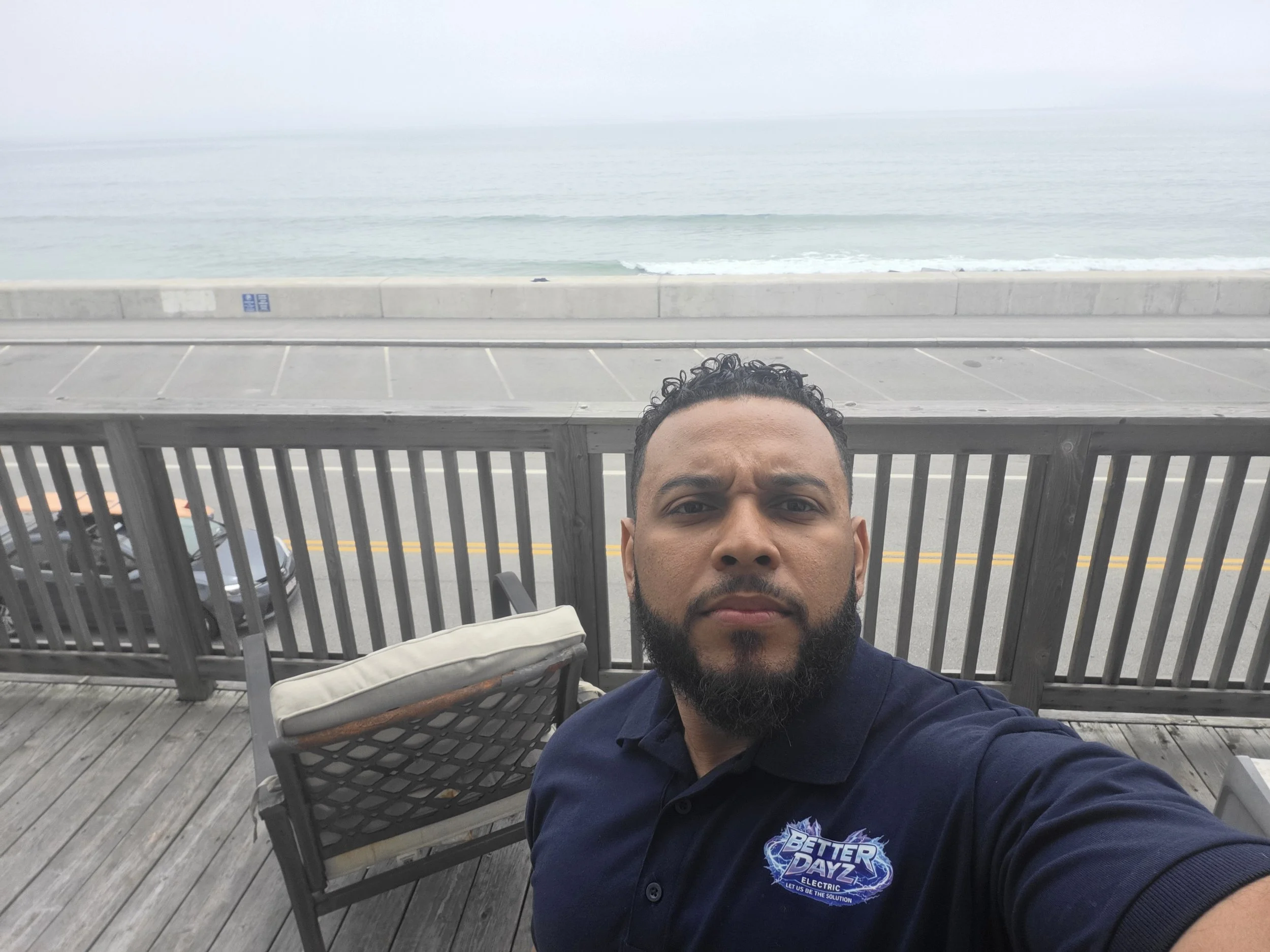 Owner of Better Dayz Electric wearing company uniform with a beach in the background. Licensed Massachusetts electrician providing residential electrical services.