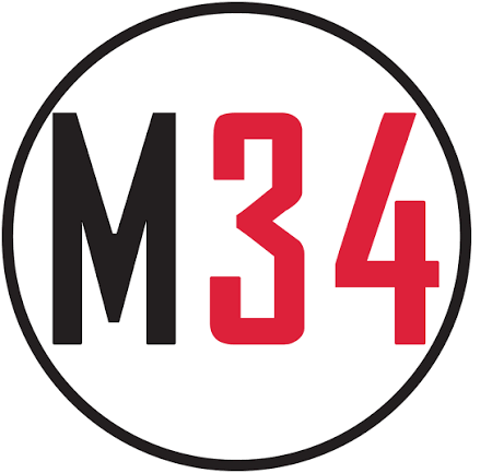 A circular sign with a black border, containing the text 'M34' with 'M' in black and '34' in red, on a white background.