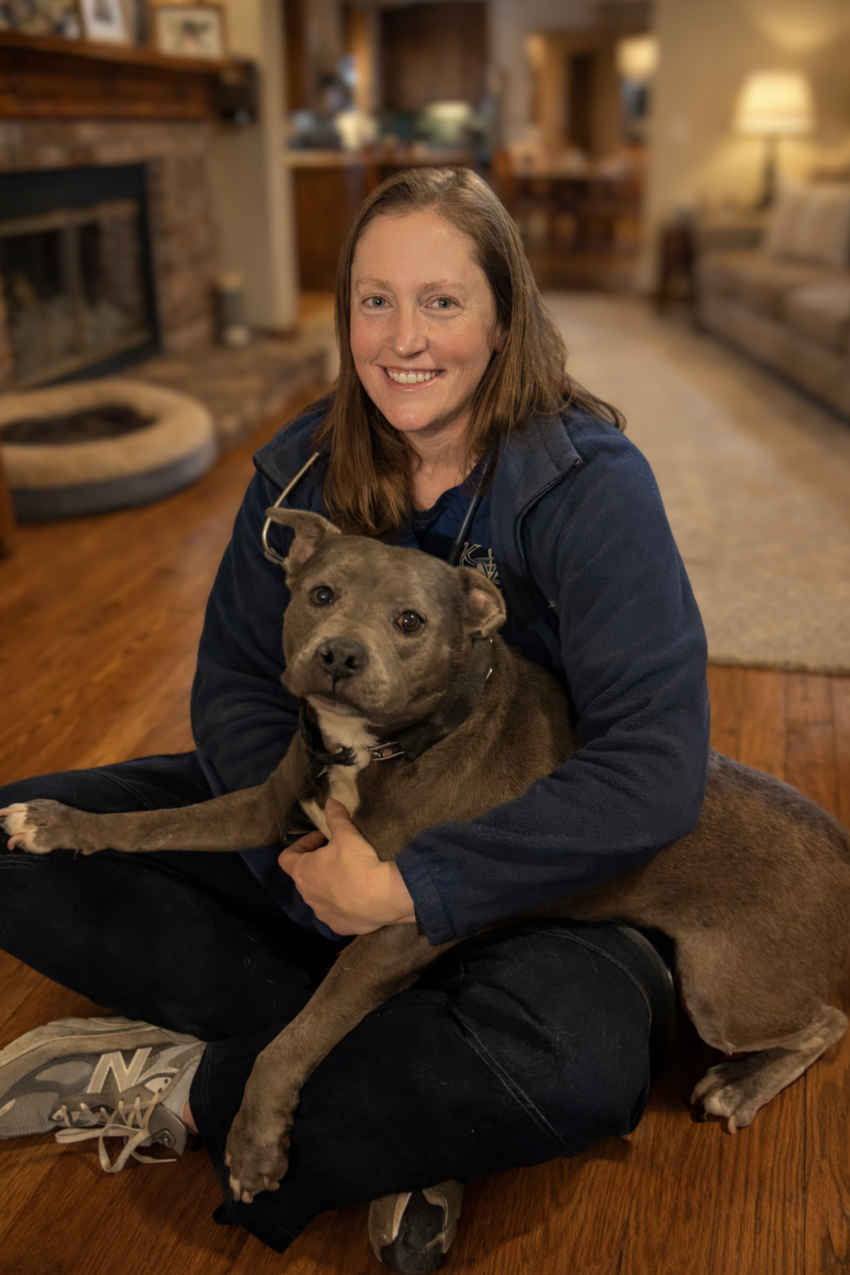 Doctor with dog patient sitting on floor facing camera
