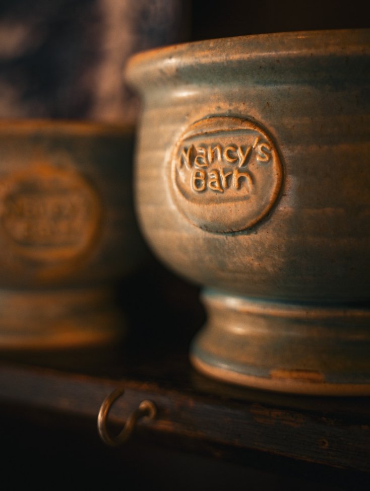 Close-up of a ceramic pot with the embossed label 'Nancy's Barn'.