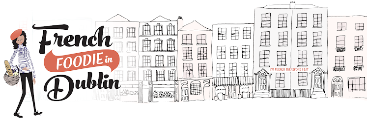 Illustration of a woman holding a baguette, with a line drawing of Dublin city buildings in the background. Text reads 'French Foodie in Dublin' with a small banner 'I'm French therefore I eat'.