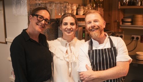 Lisa, Kieran and Catriona smiling in a kitchen
