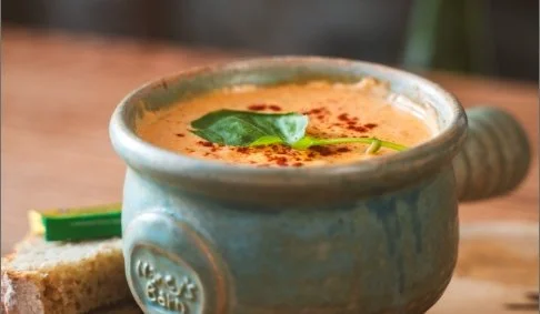 A bowl of seafood chowder, served in a small, ceramic bowl.