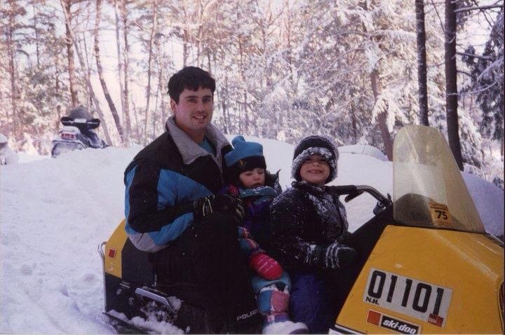 YOUNG KIDS AND THERE FATHER RIDE A SNOWMOBILE