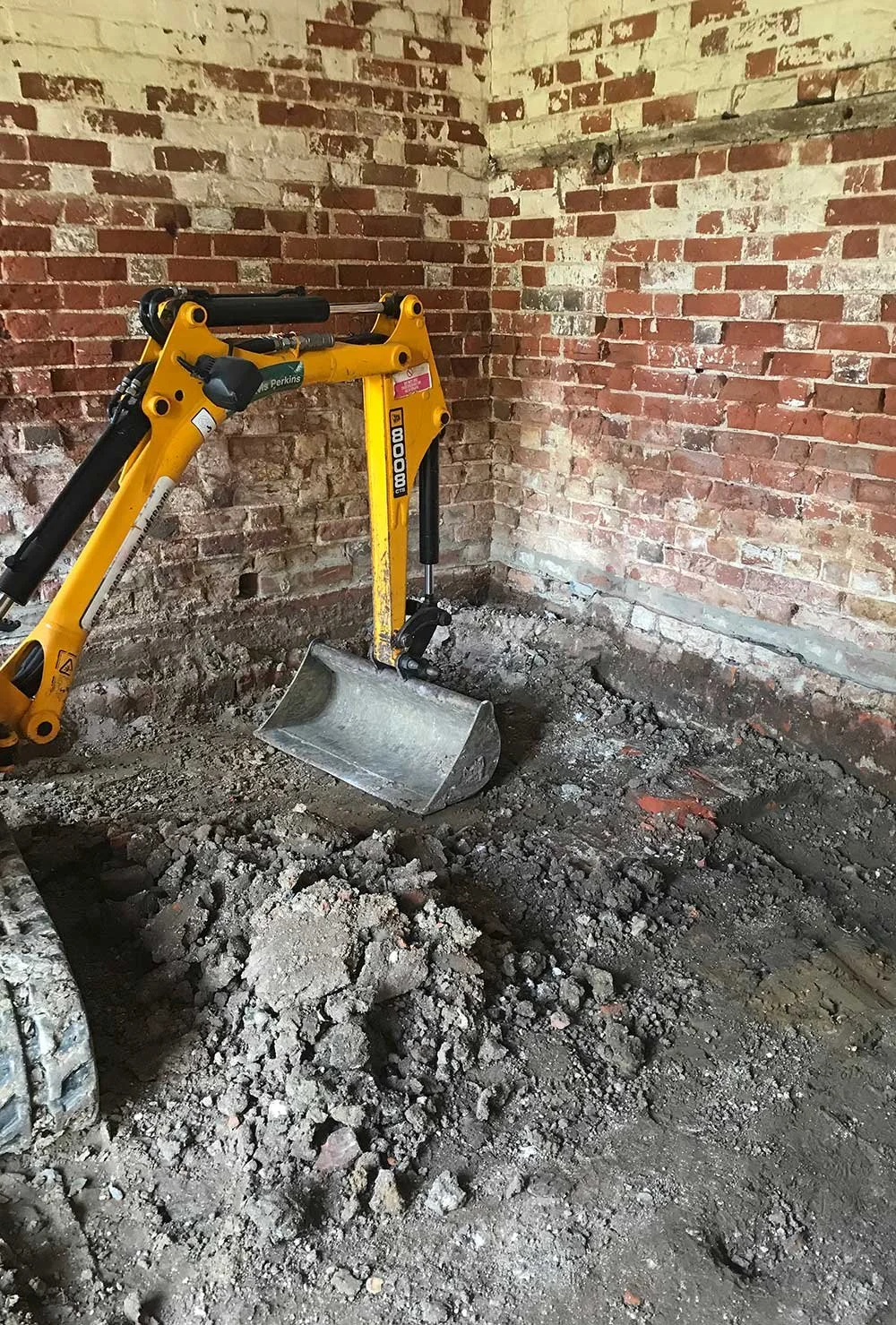 Interior of barn during renovation with excavator.