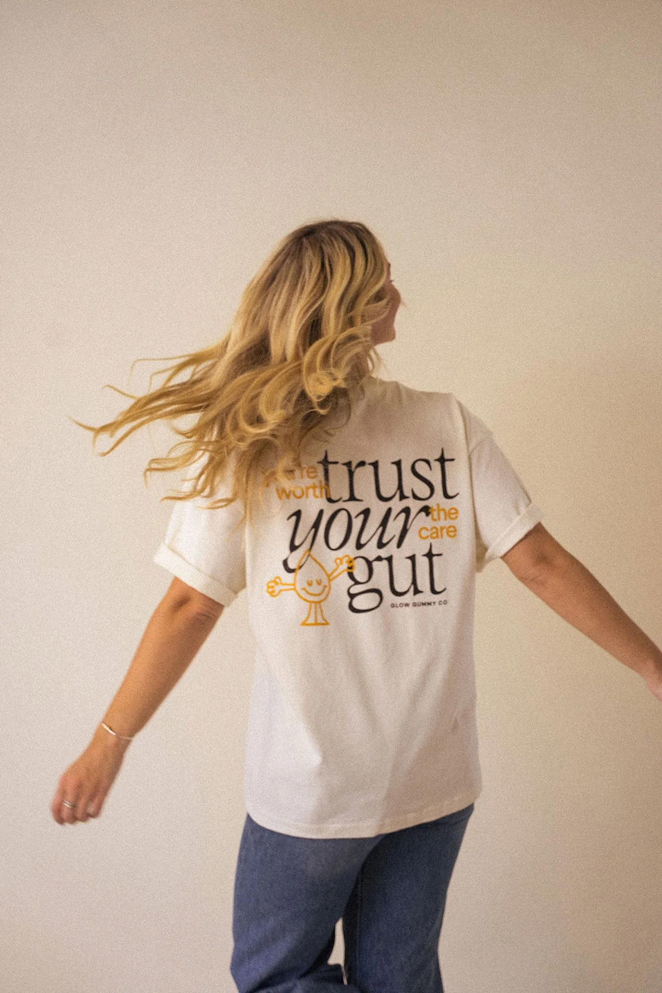 A woman facing forward with her back turned to the camera showing a t-shirt that says trust your gut - personal branding studio - studio domka.jpg
