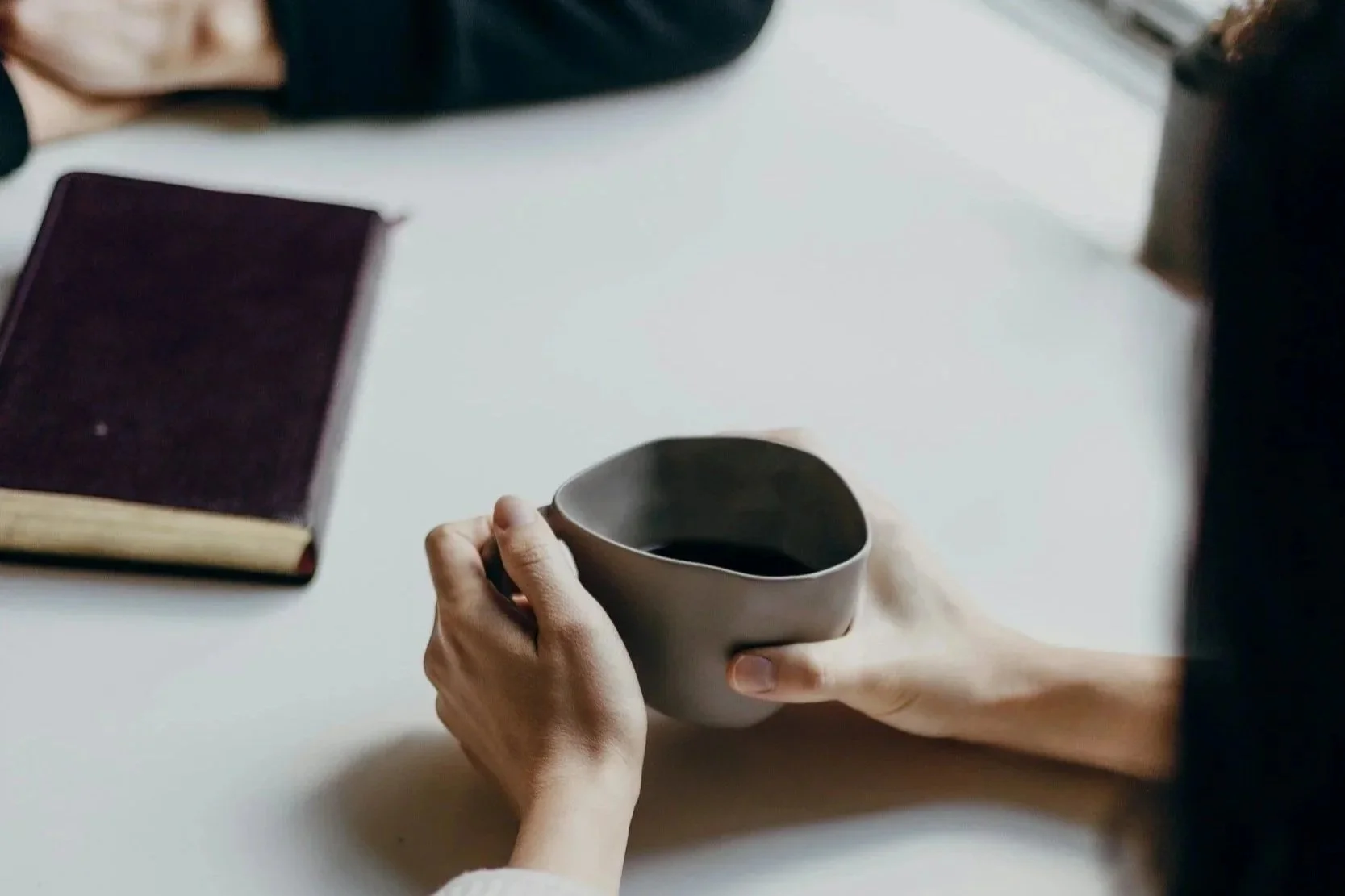 Calm workspace with coffee and materials representing thoughtful reflection and preparation for difficult conversations.