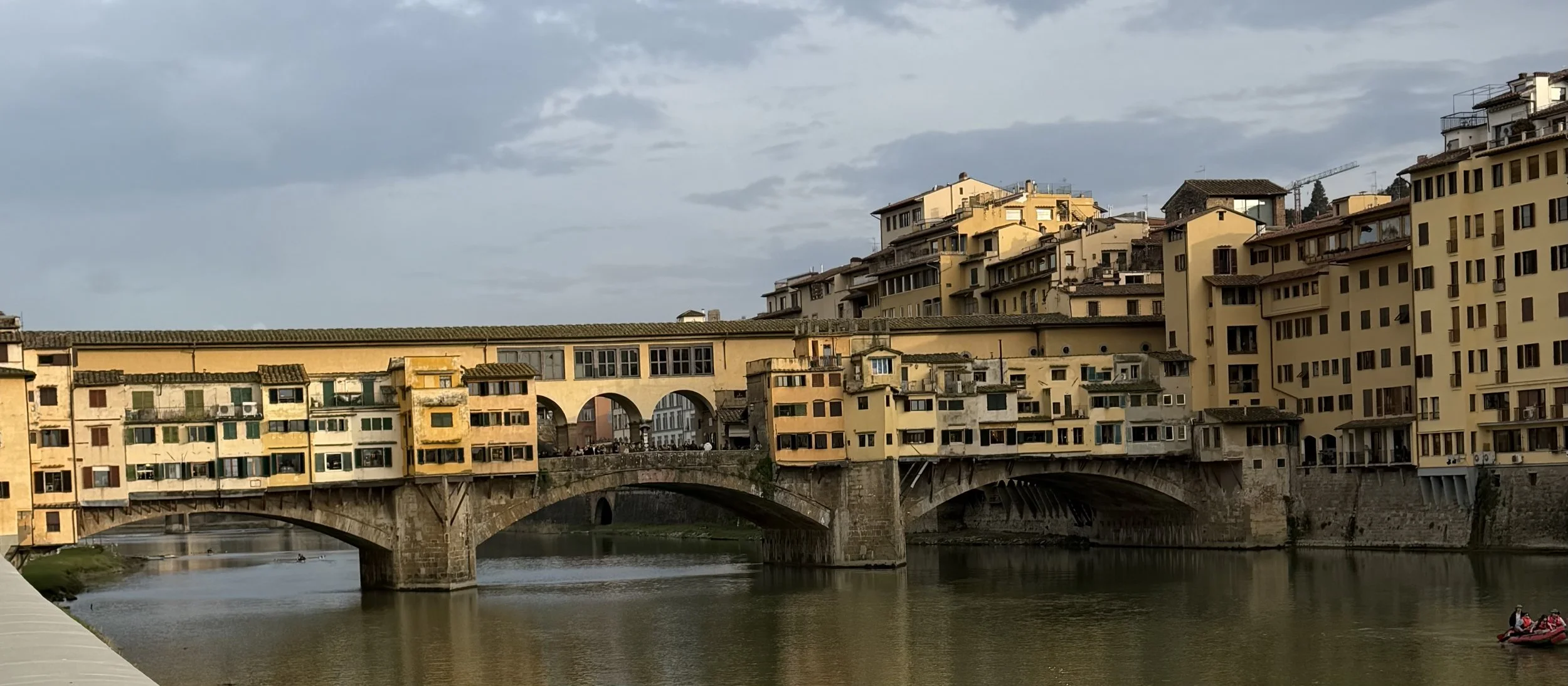 Ponte Vecchio bridge in Florence Italy over the Arno River at sunset, a must-see stop when planning a trip to Italy
