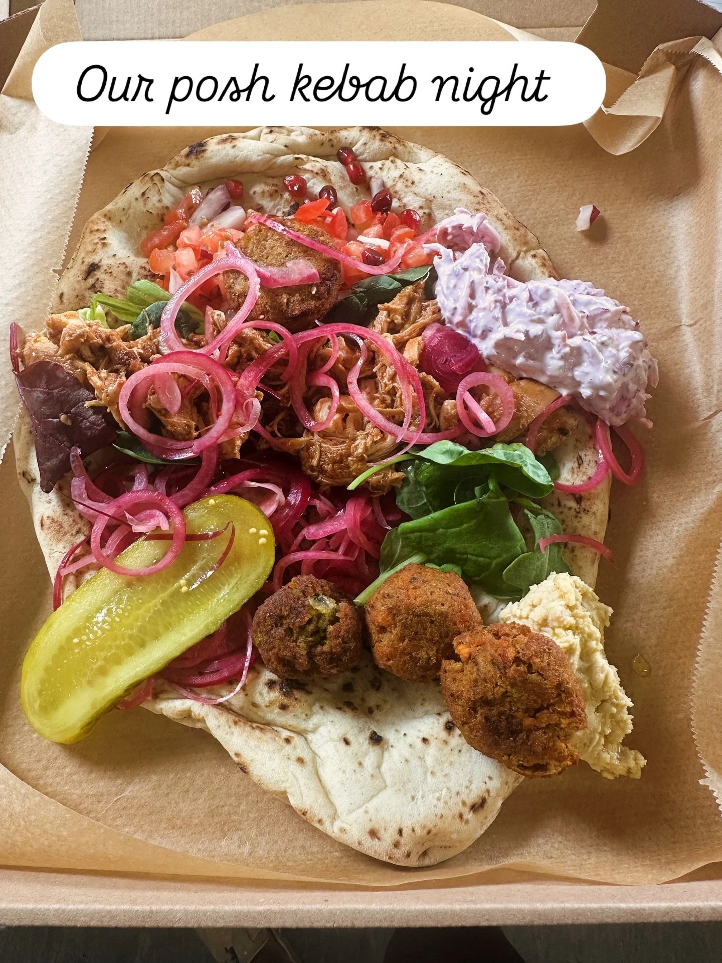 A pita bread filled with falafel, pickles, chopped onions, lettuce, and various toppings, labeled as 'Our posh kebab night'.