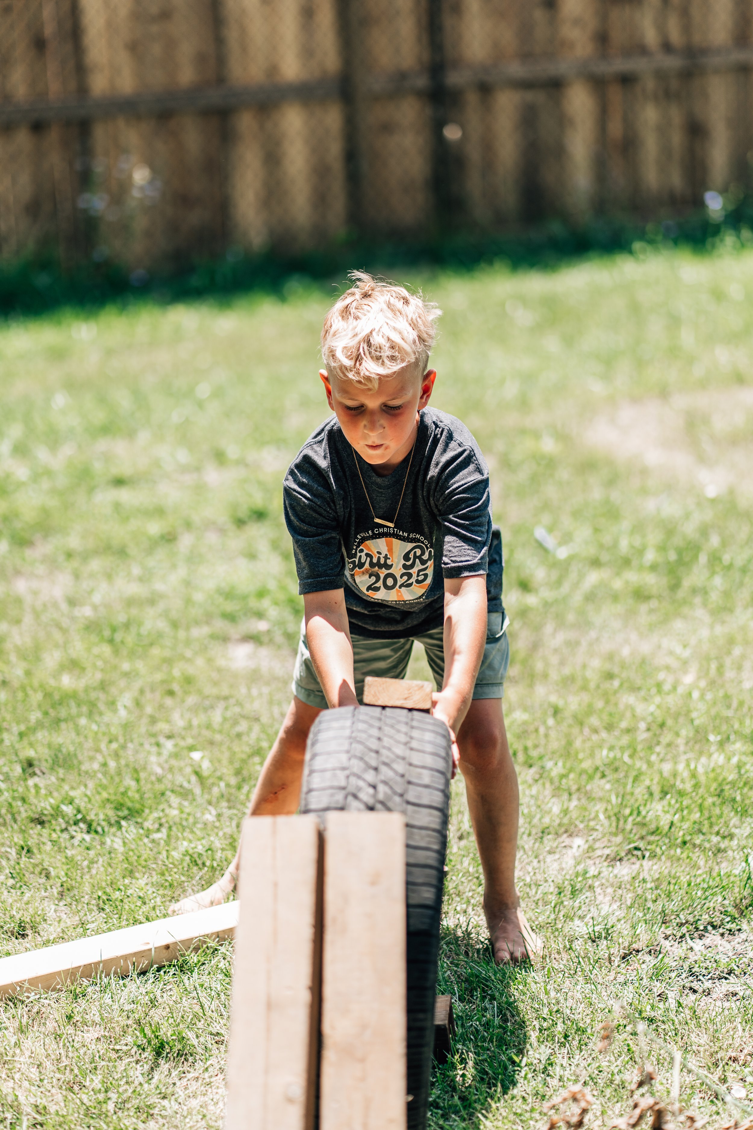 Boy building a race track with wooden blocks and tires at the Belleville Outdoor Preschool
