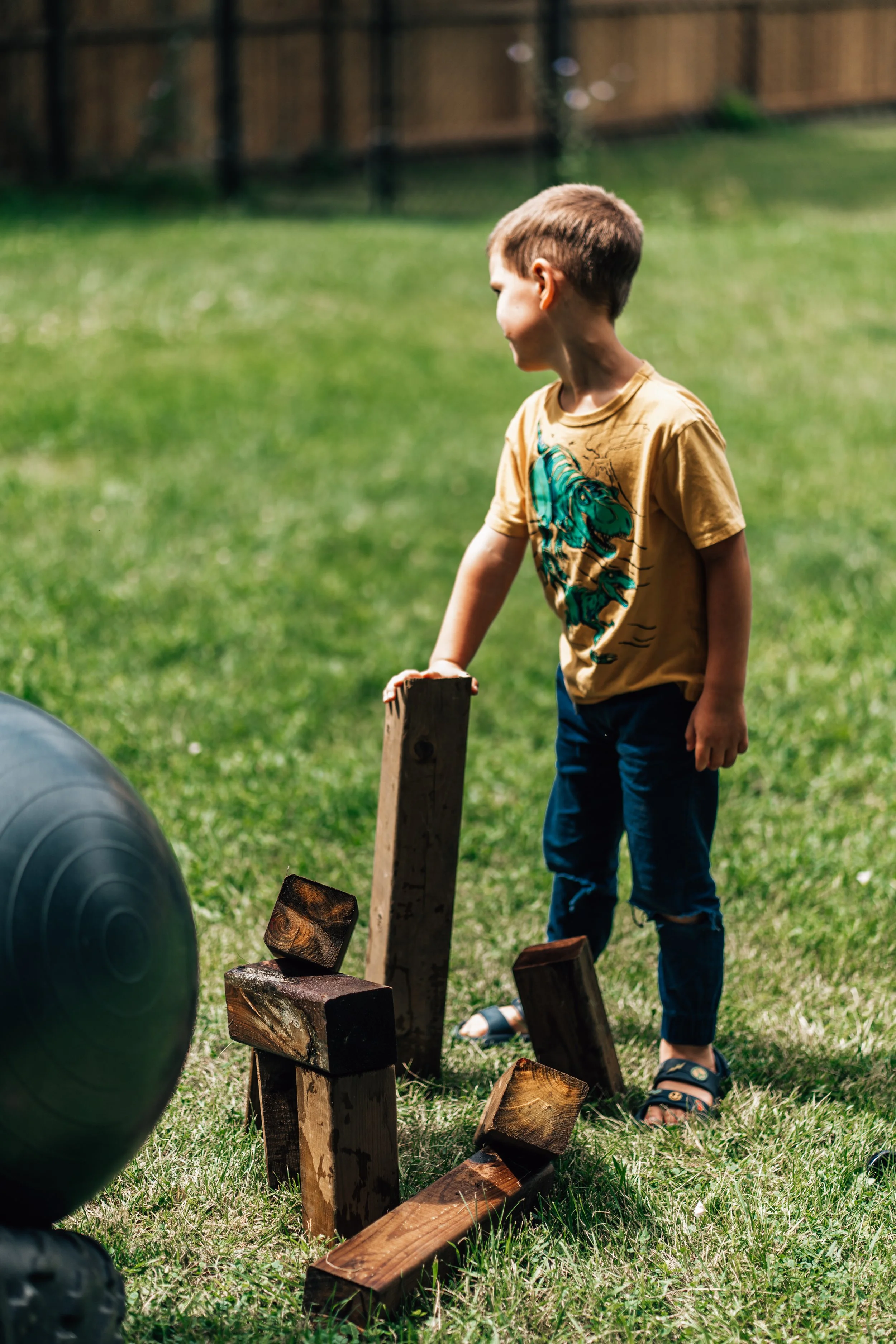 Boy stacking wooden planks to build a little fort at the Belleville Outdoor Preschool