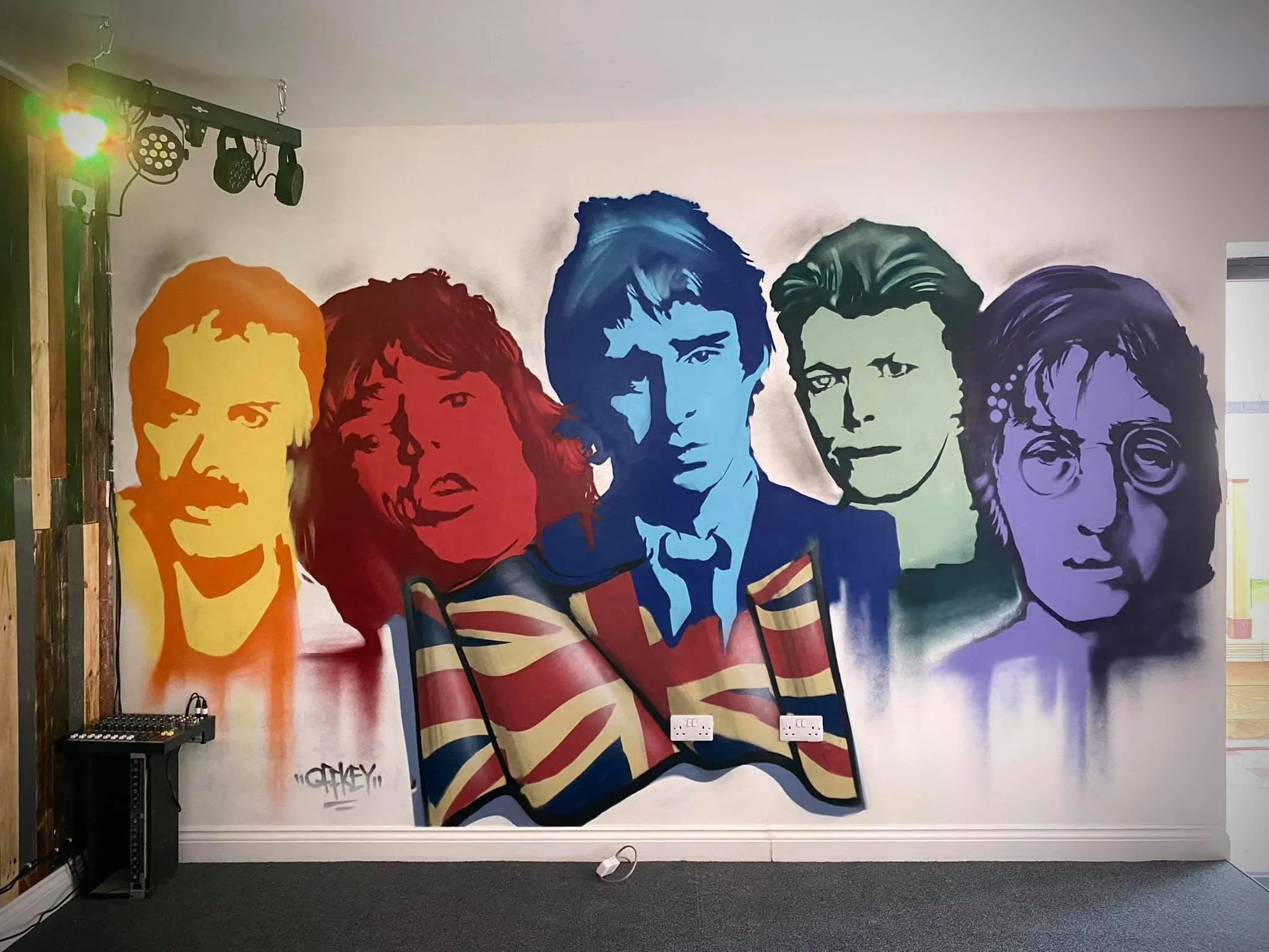 Colorful mural of five iconic musicians, including Ringo Starr, George Harrison, John Lennon, Paul McCartney, and John Lennon.