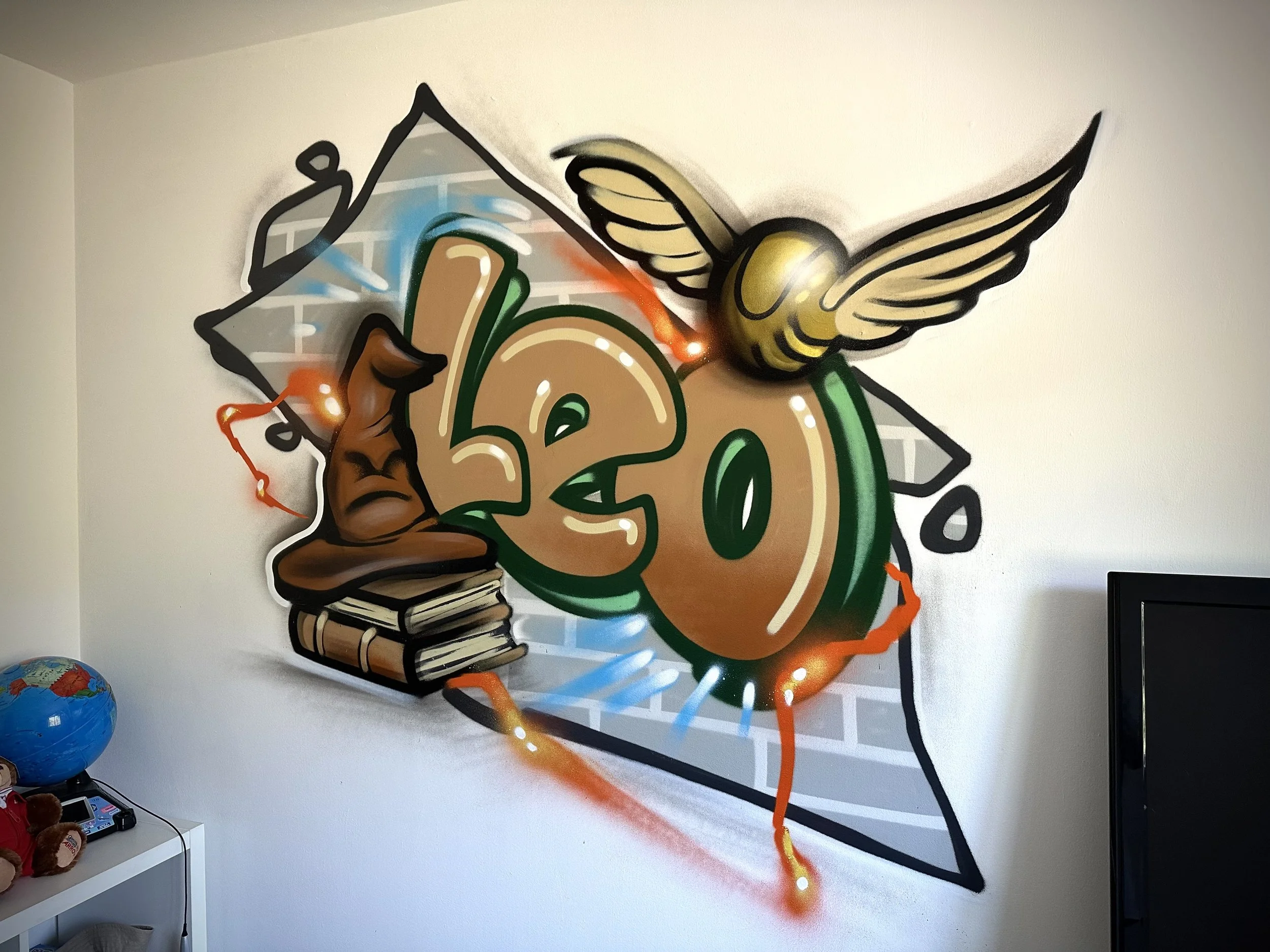 Colorful graffiti wall art featuring a graduation cap, a diploma scroll, books, a winged bee, and the number 20.